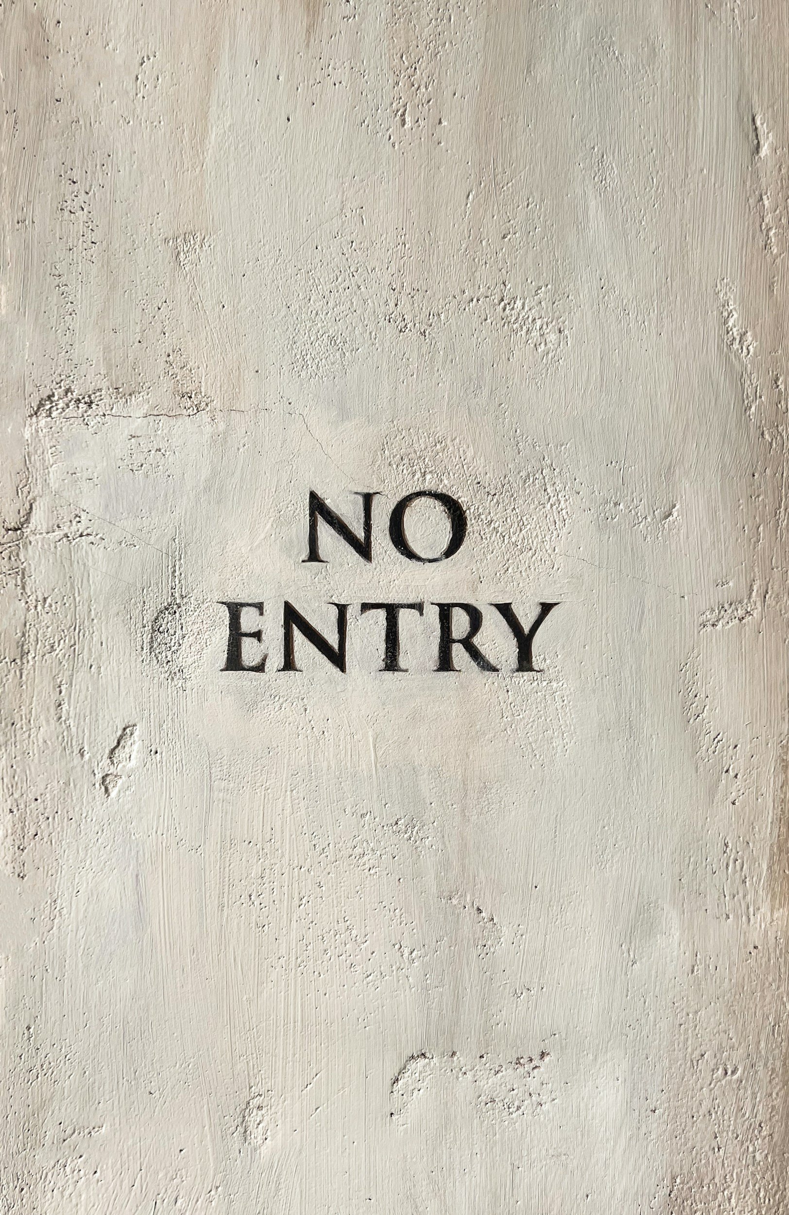 A white wall with the words 'NO ENTRY' in black, centered on the wall.