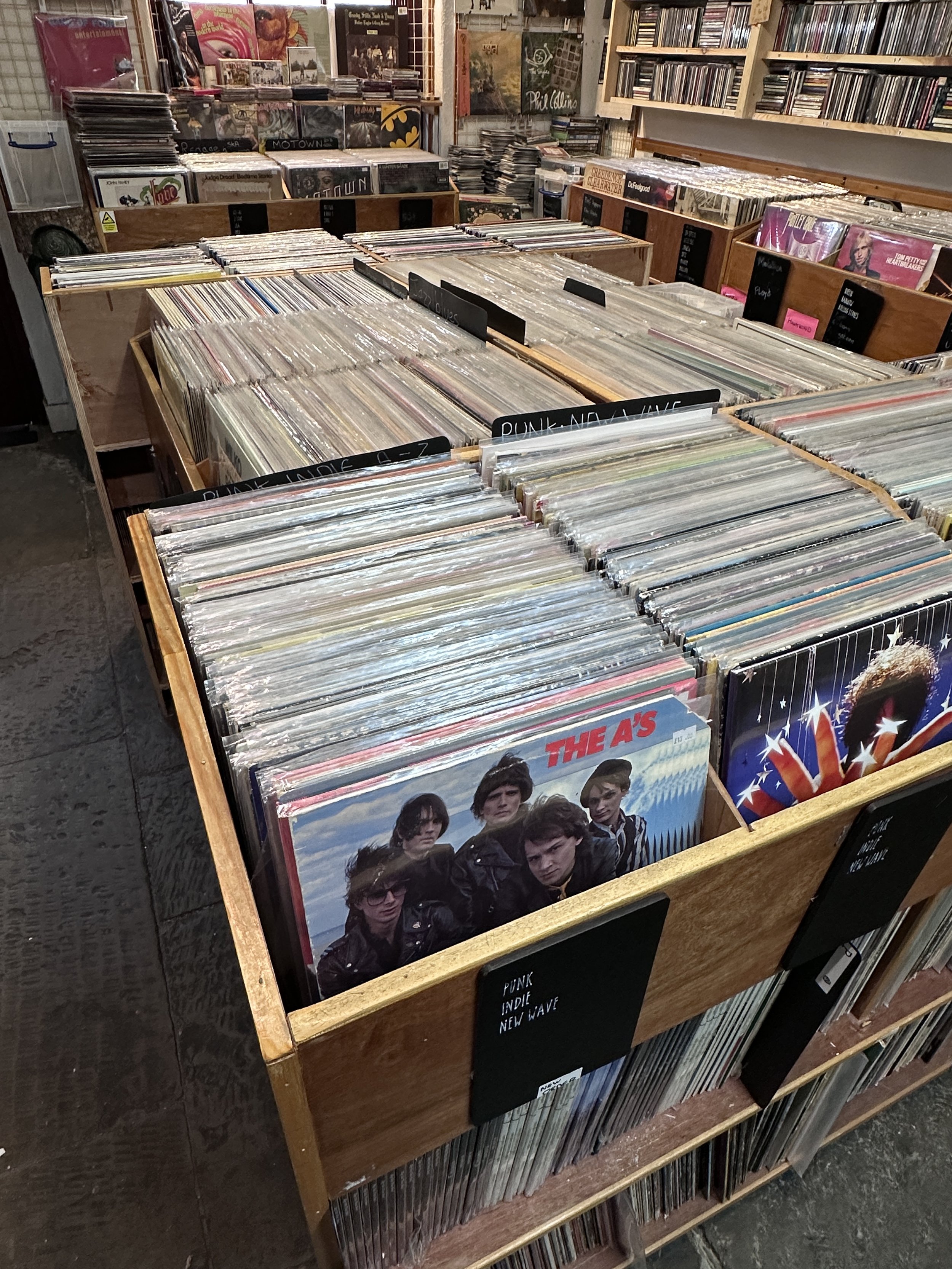 A collection of vinyl records stored in wooden browser boxes, inside Music in the Green.