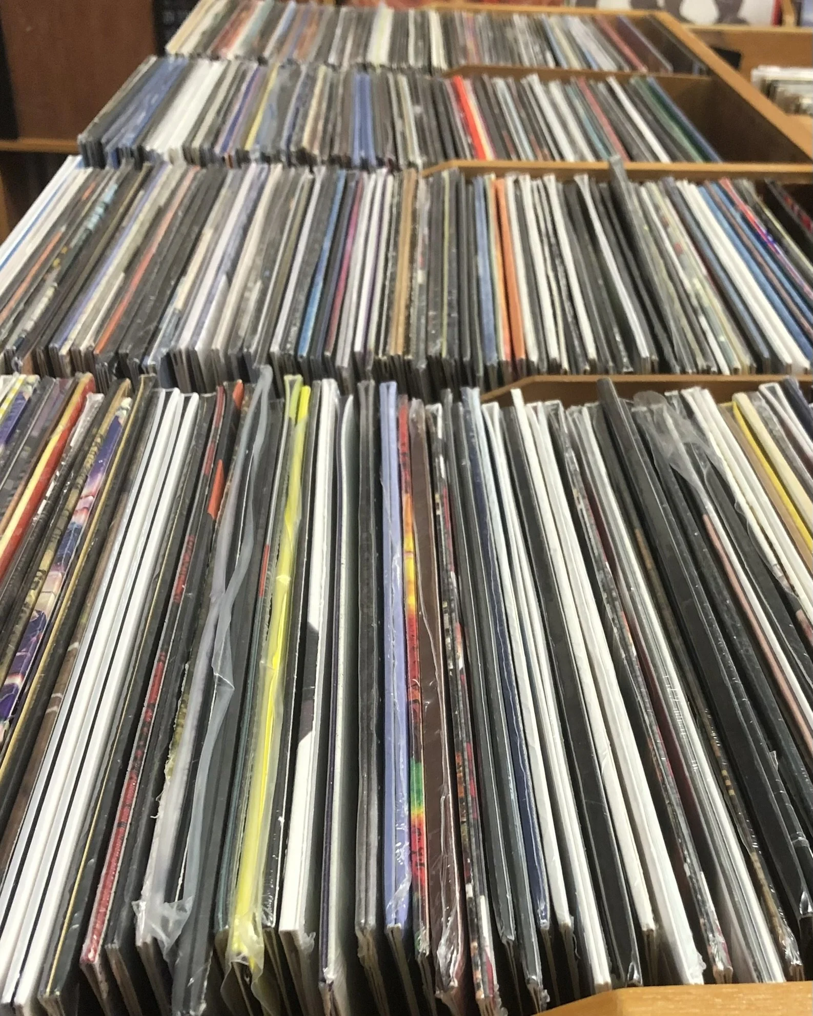 A collection of vinyl records stored in wooden browser boxes, inside Music in the Green.