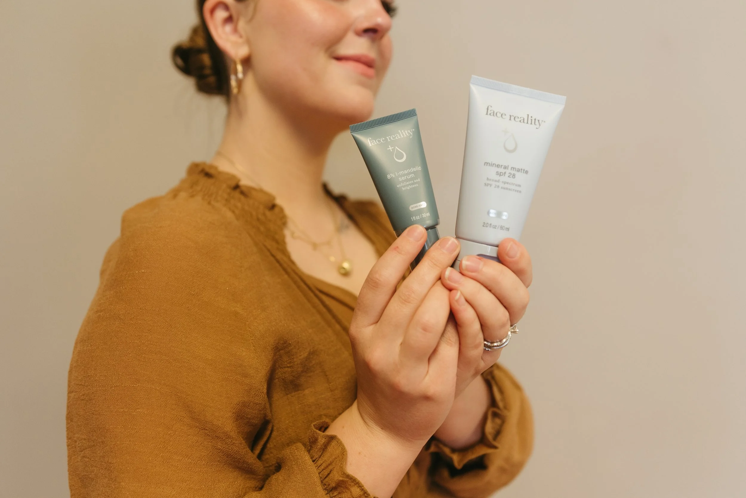 woman holding skincare products; skincare clinic colorado springs