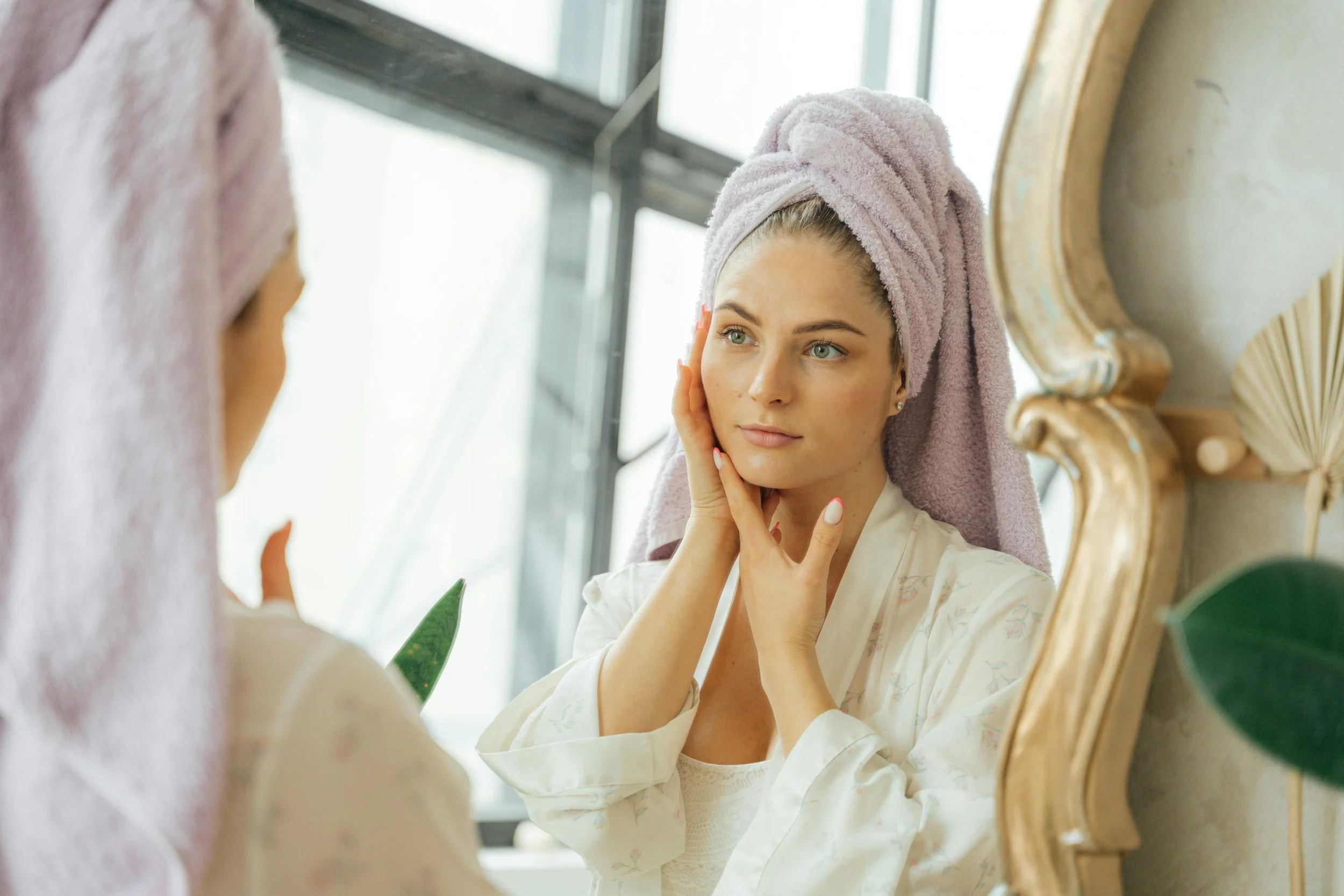 woman looking in a mirror, acne treatment colorado springs