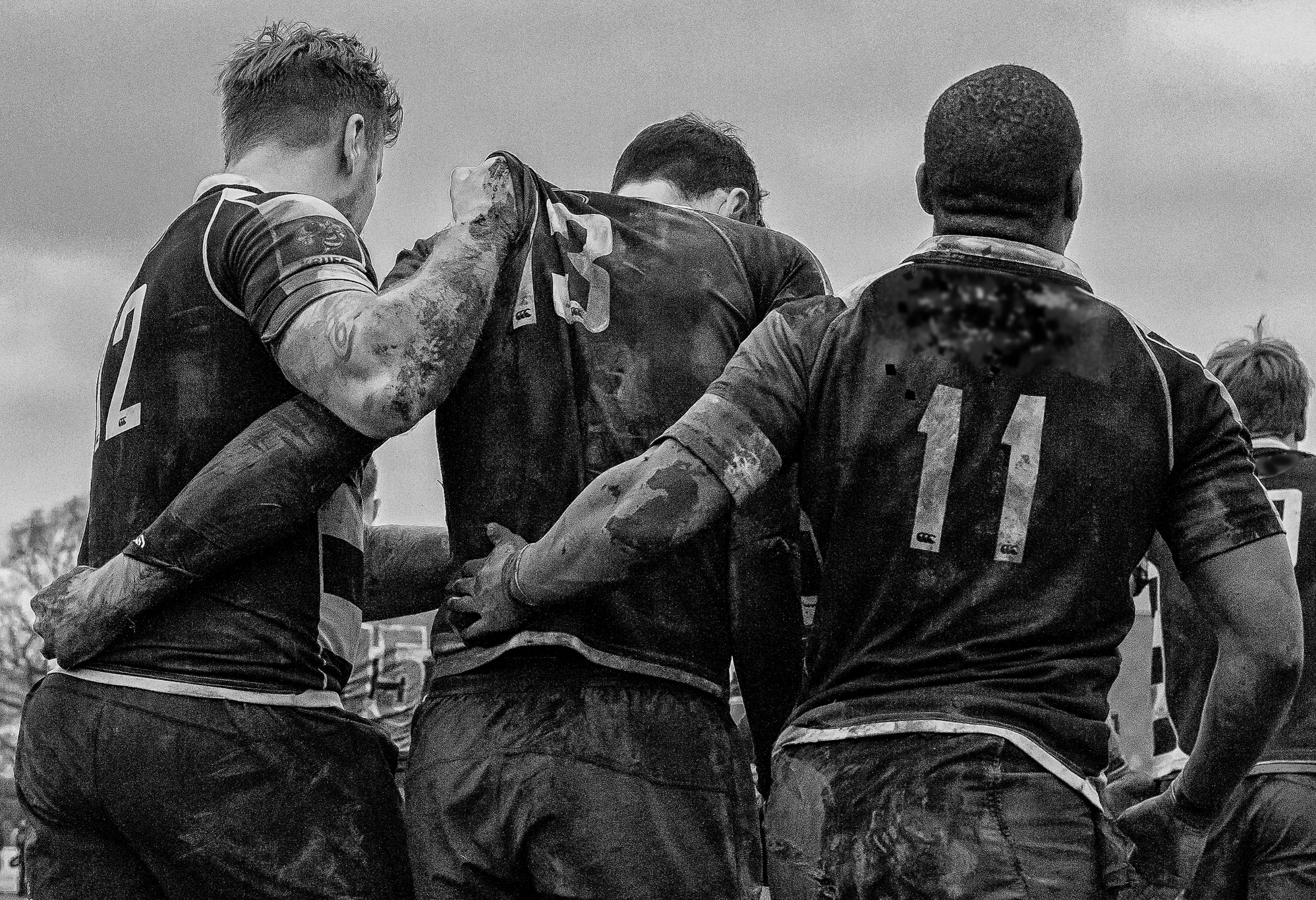 3 rugby players helping each other back to scrum