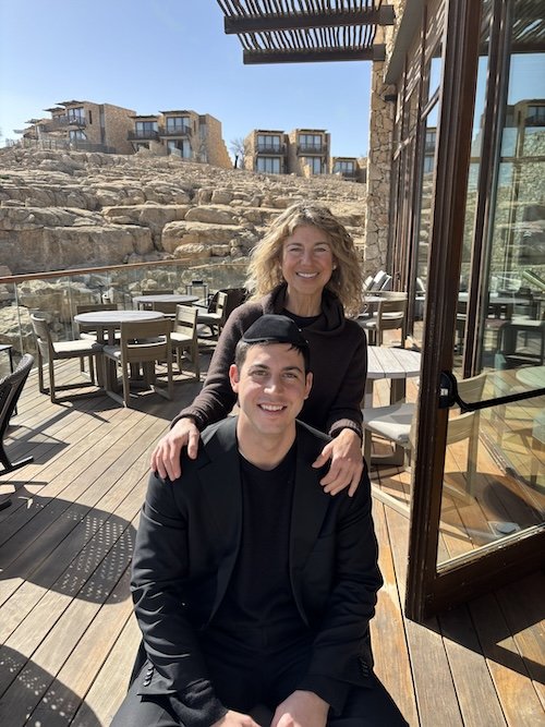 Carolyn Mahboubi and her son Adam smiling together on an outdoor patio.
