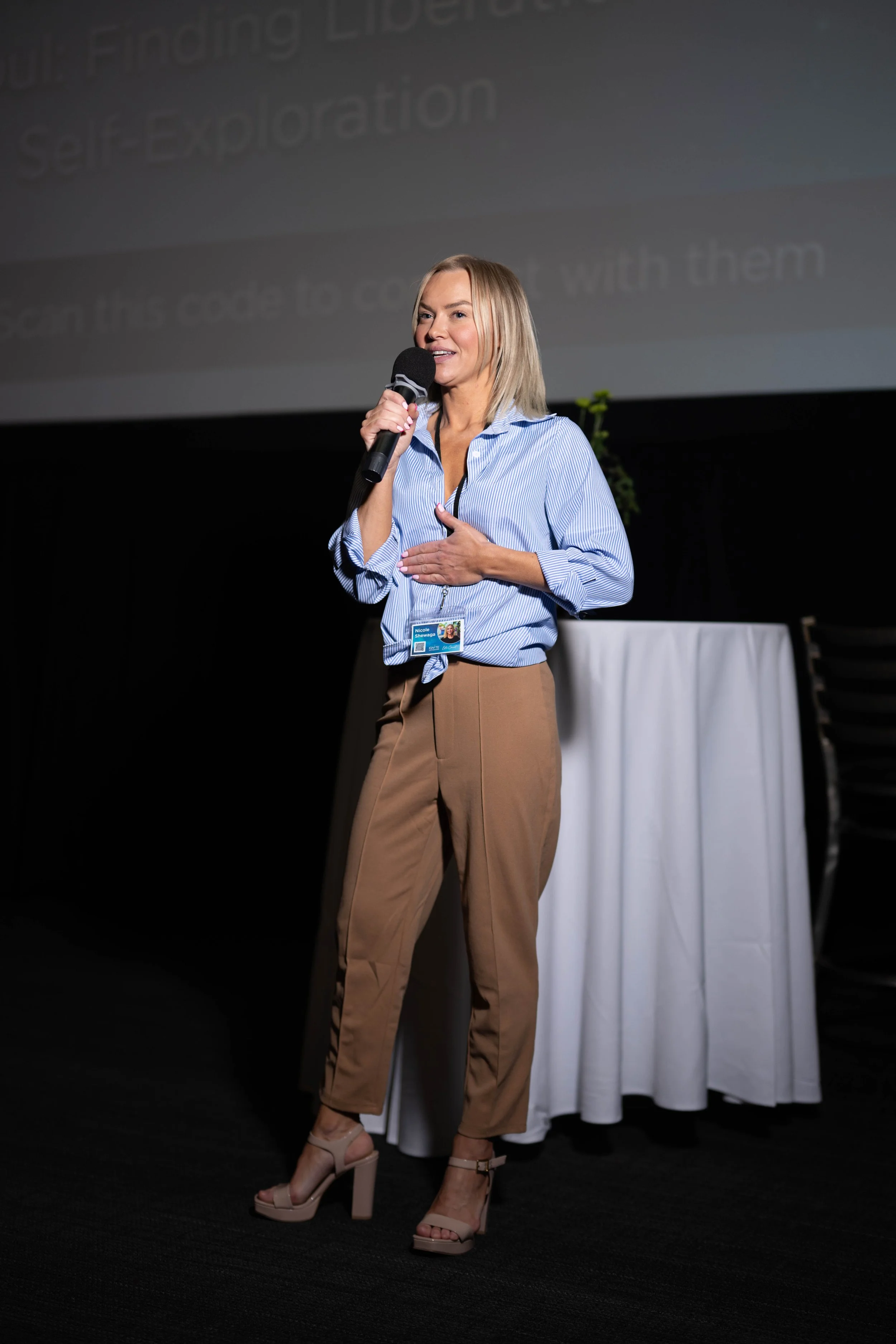 Nicole Shewaga speaking into a microphone on stage.