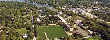 Aerial view of a neighborhood with houses, trees, and a central sports field surrounded by a running track.