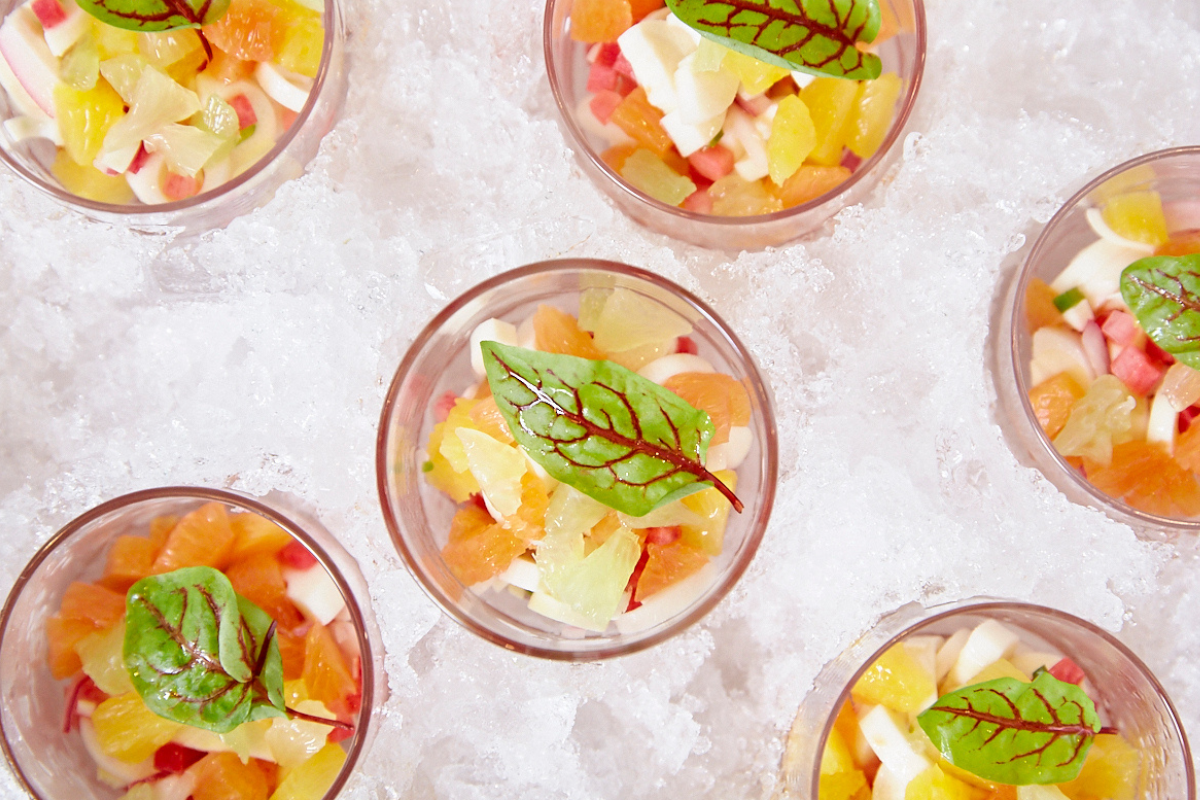 A bunch of bowls of fruit with a leaf on the top of them