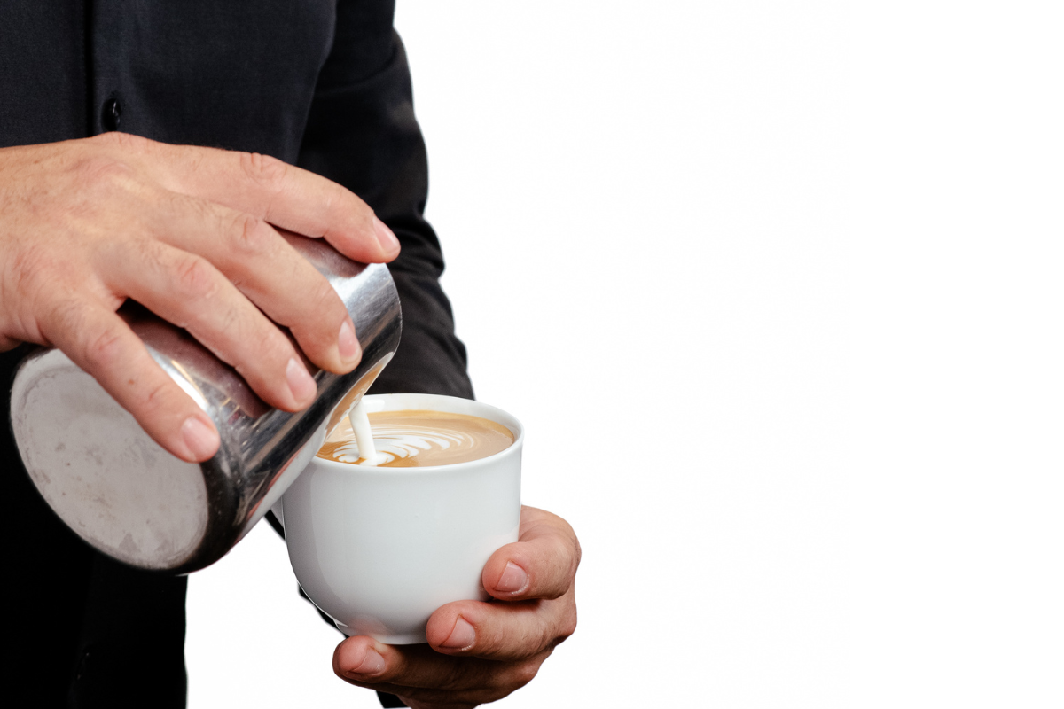 Someone pouring creamer into coffee
