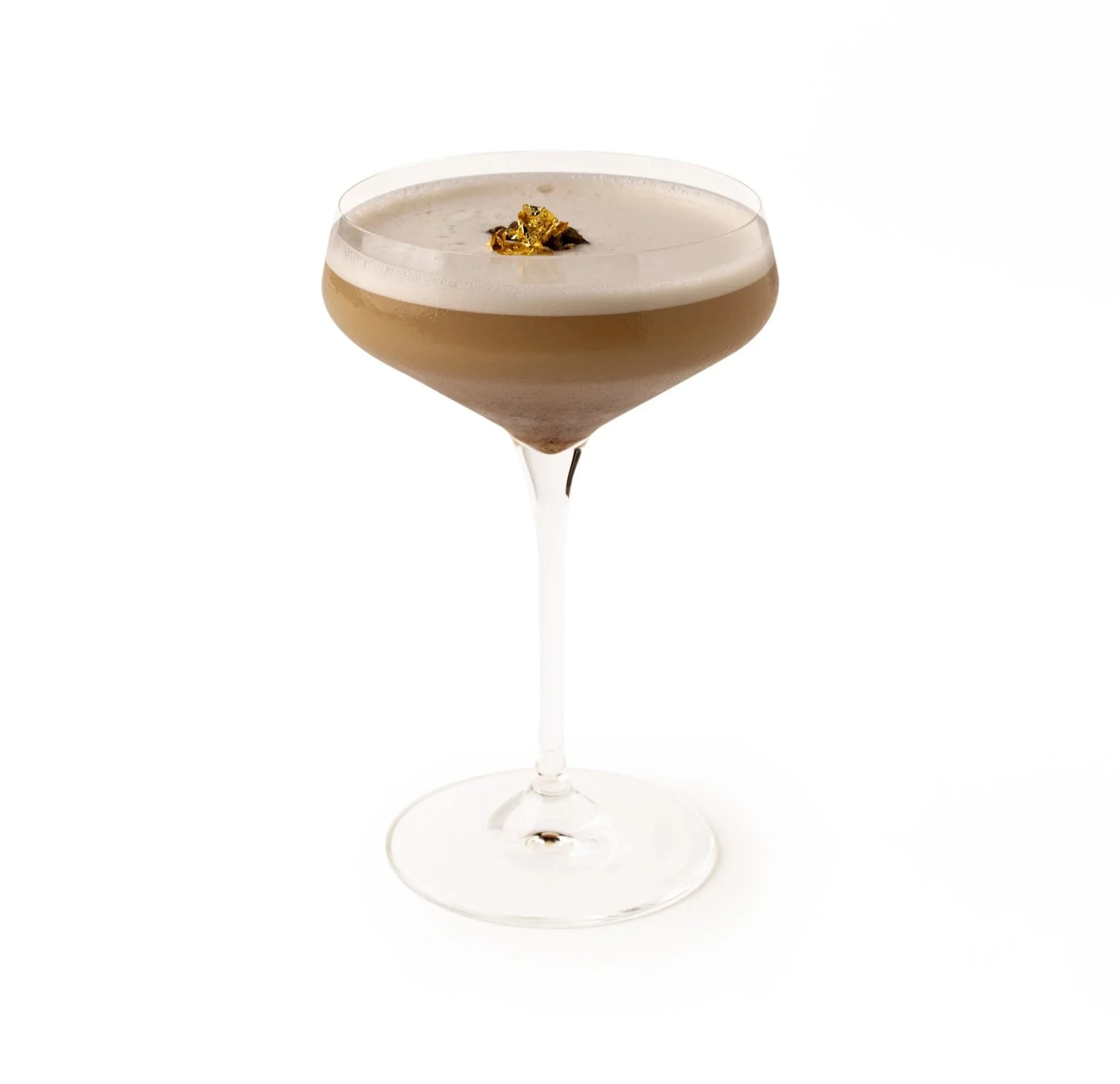 A sophisticated cocktail in a coupe glass with a beige frothy top, garnished with edible gold flakes.