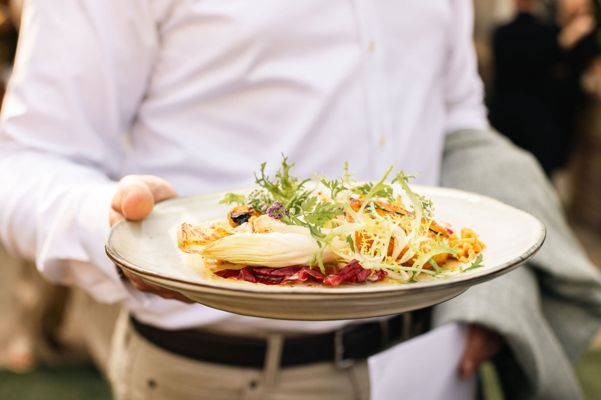 A person holding a plate of food in front of the camera
