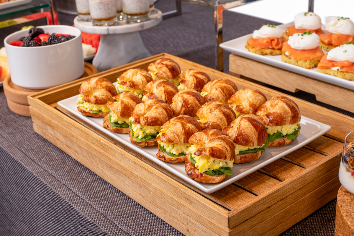 A bunch of breakfast sandwiches all sitting on a food station platter