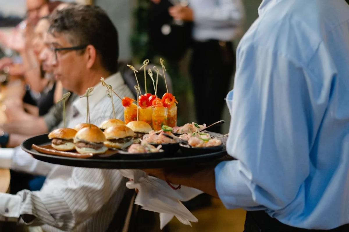 A server bring a platter of food to a table