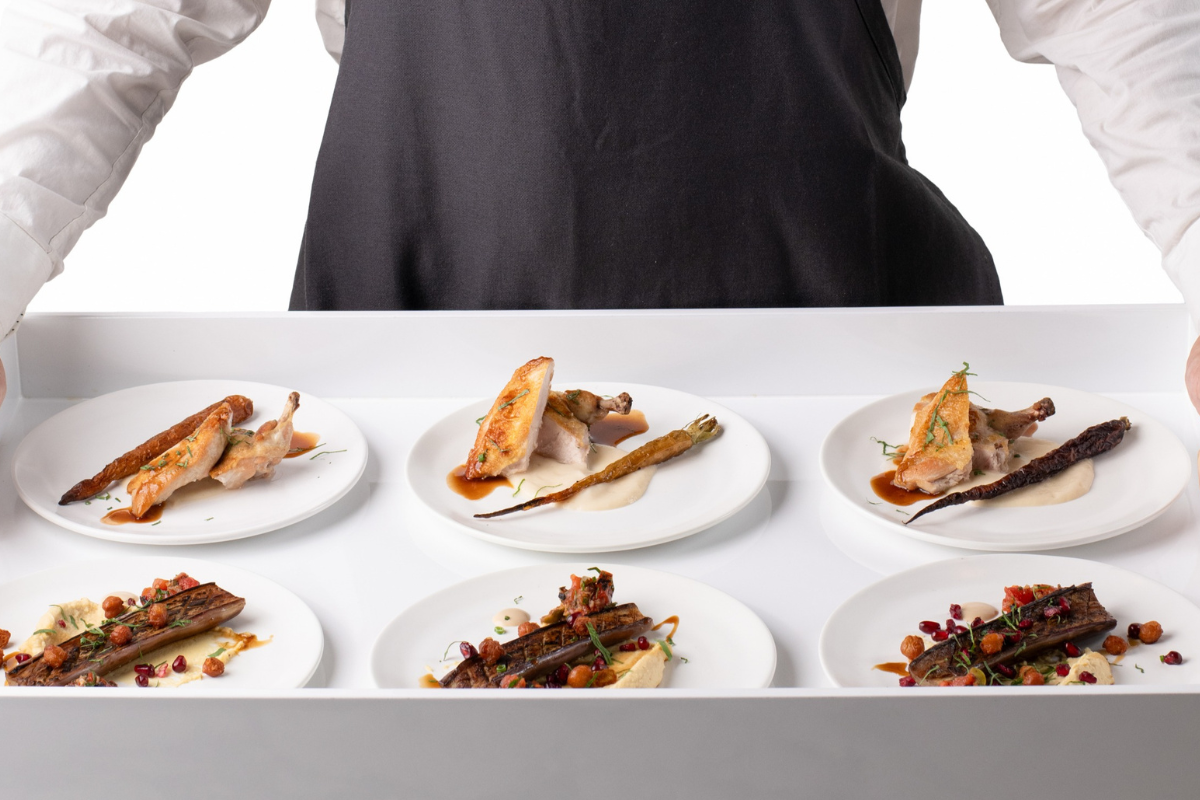 A waiter bringing a tray of food to a table