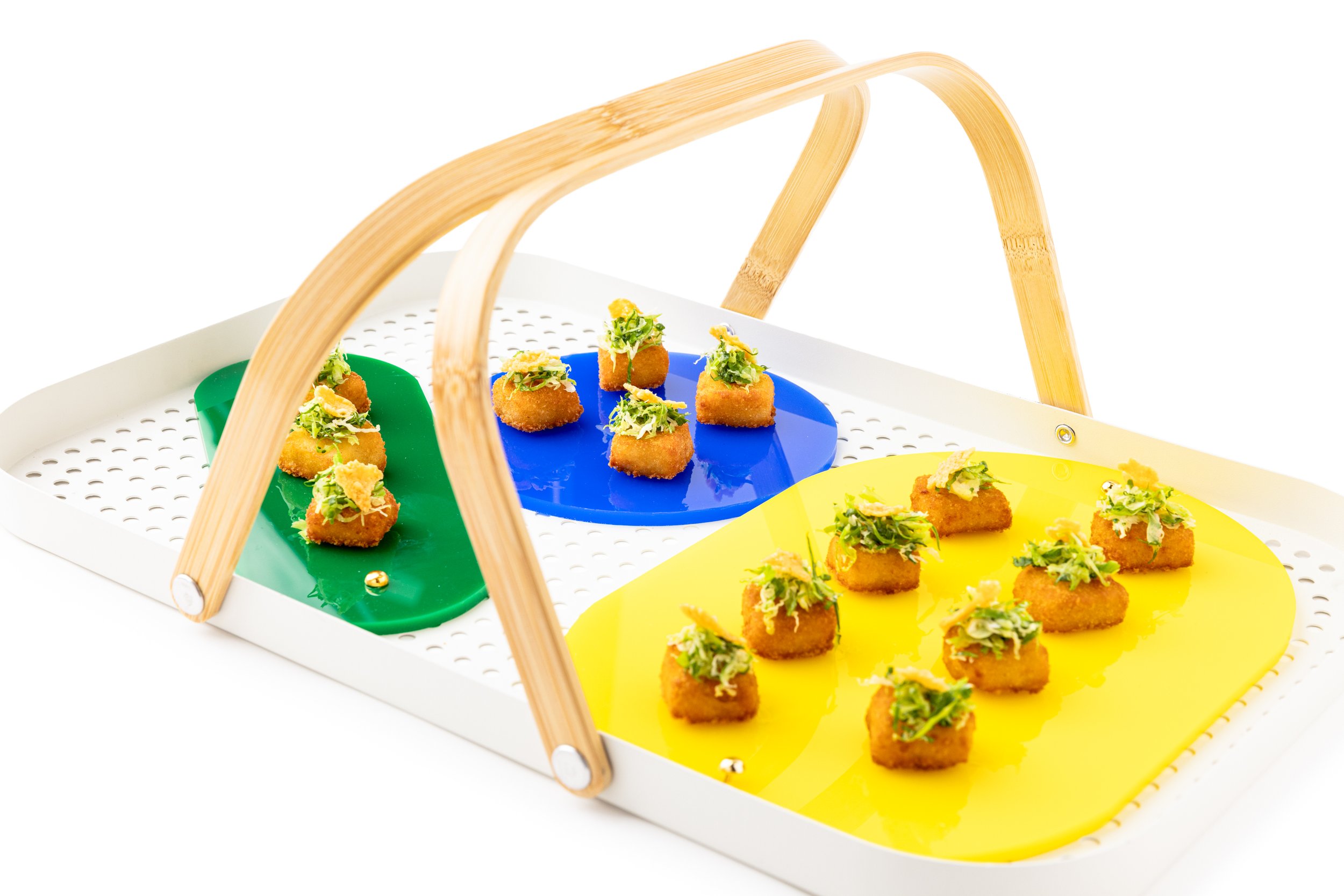 Appetizer tray with small fried bites topped with greens, arranged on colorful plates under a wooden handle