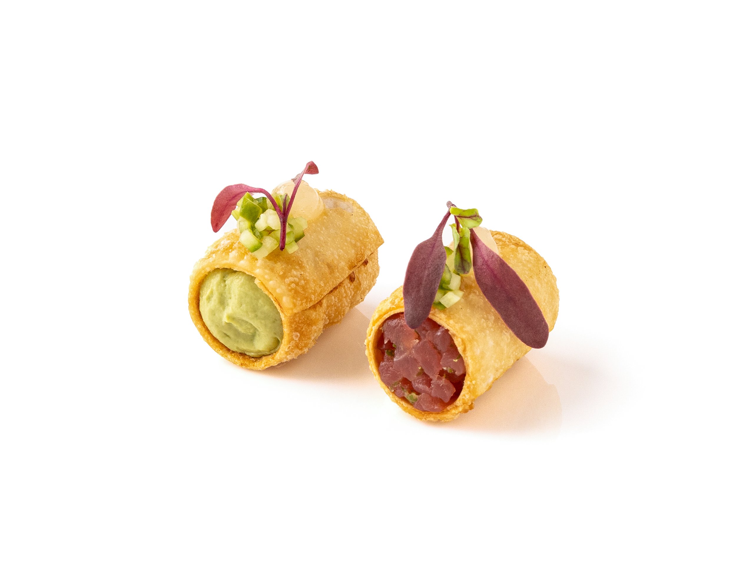 Two deep-fried spring rolls filled with green avocado and red minced meat, garnished with microgreens and chopped green onions, placed on a white background.