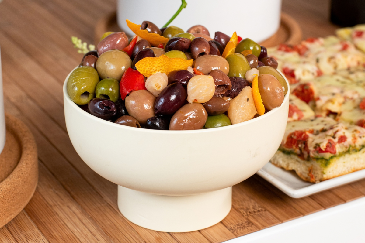 A giant bowl of olives, fruit, and other types of plants