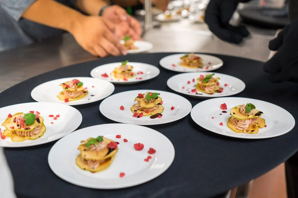 A bunch of plates on a table being created by staff