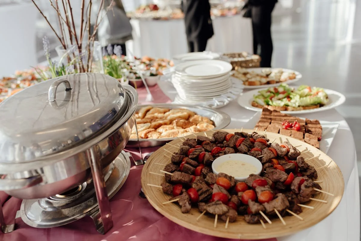 A table with a bunch of plates of food for a catered event