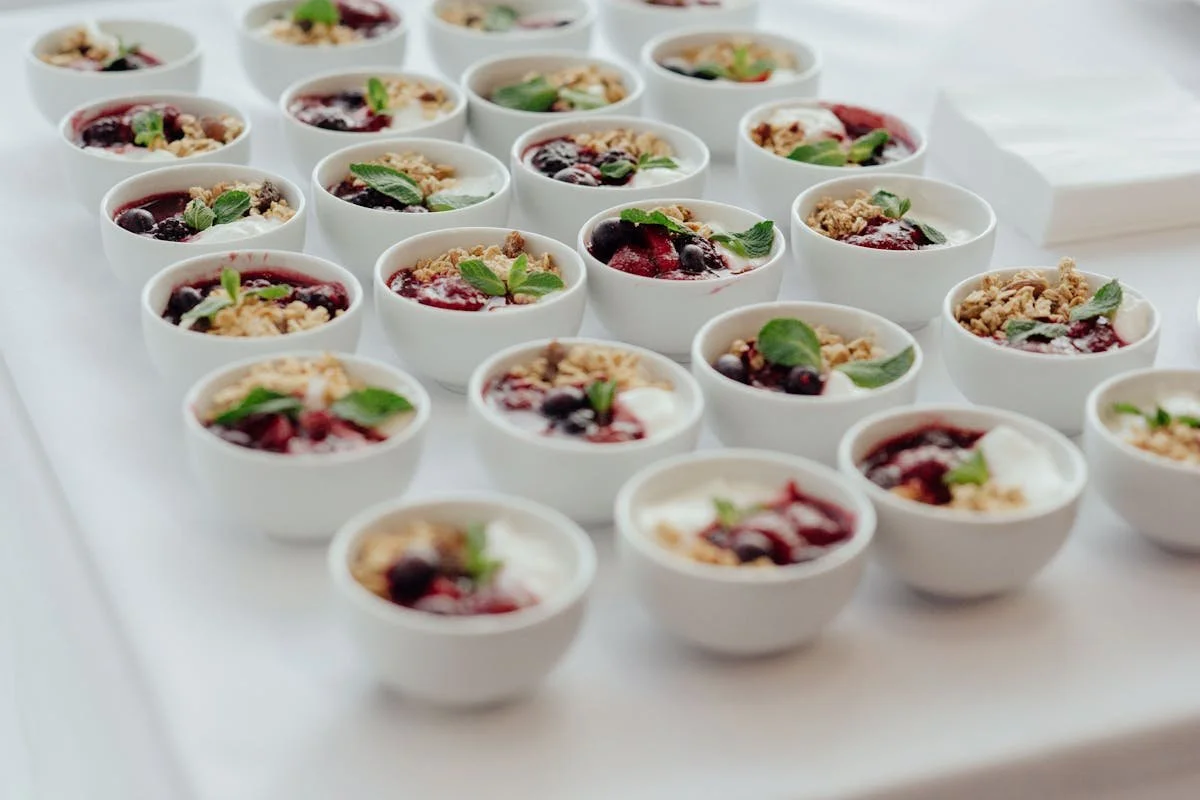 A bunch of bowls of yogurt and fruit sitting on a table
