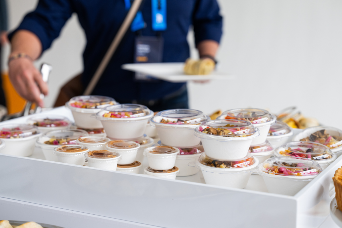 A person taking food from a table that was catered