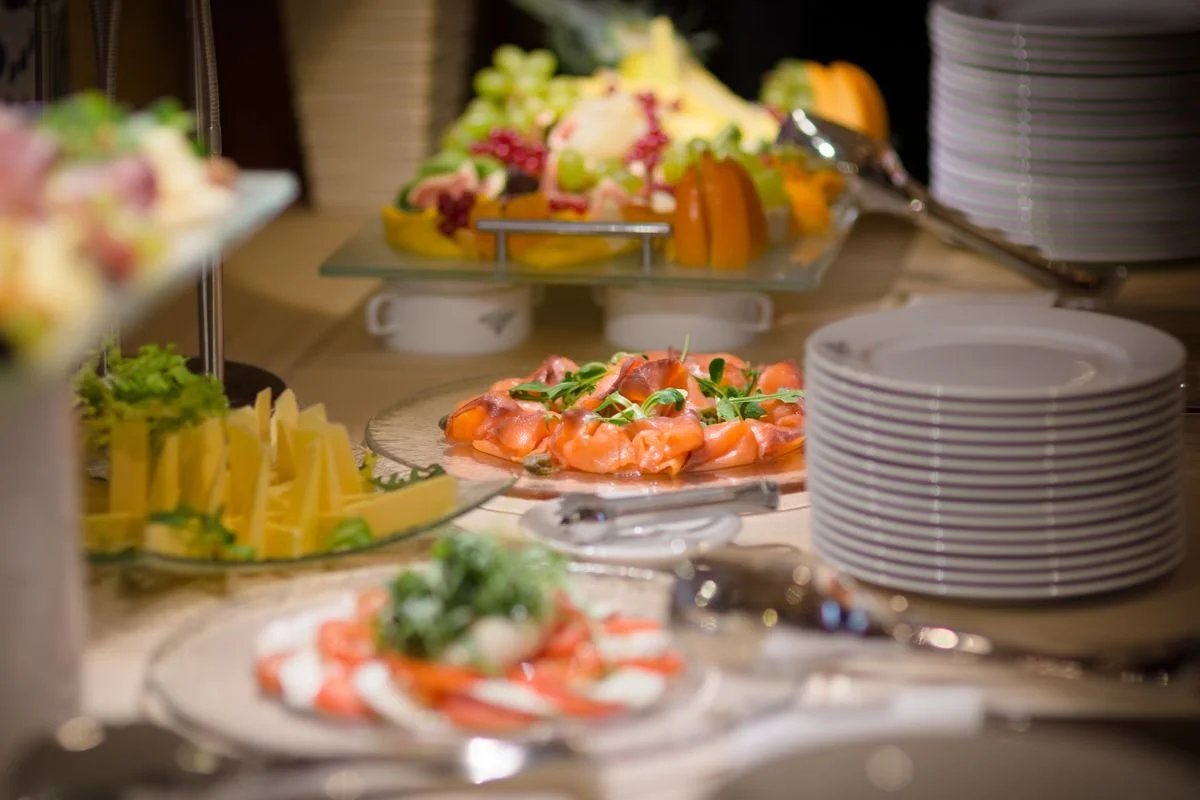 A bunch of food sitting on a table with some plates next to it