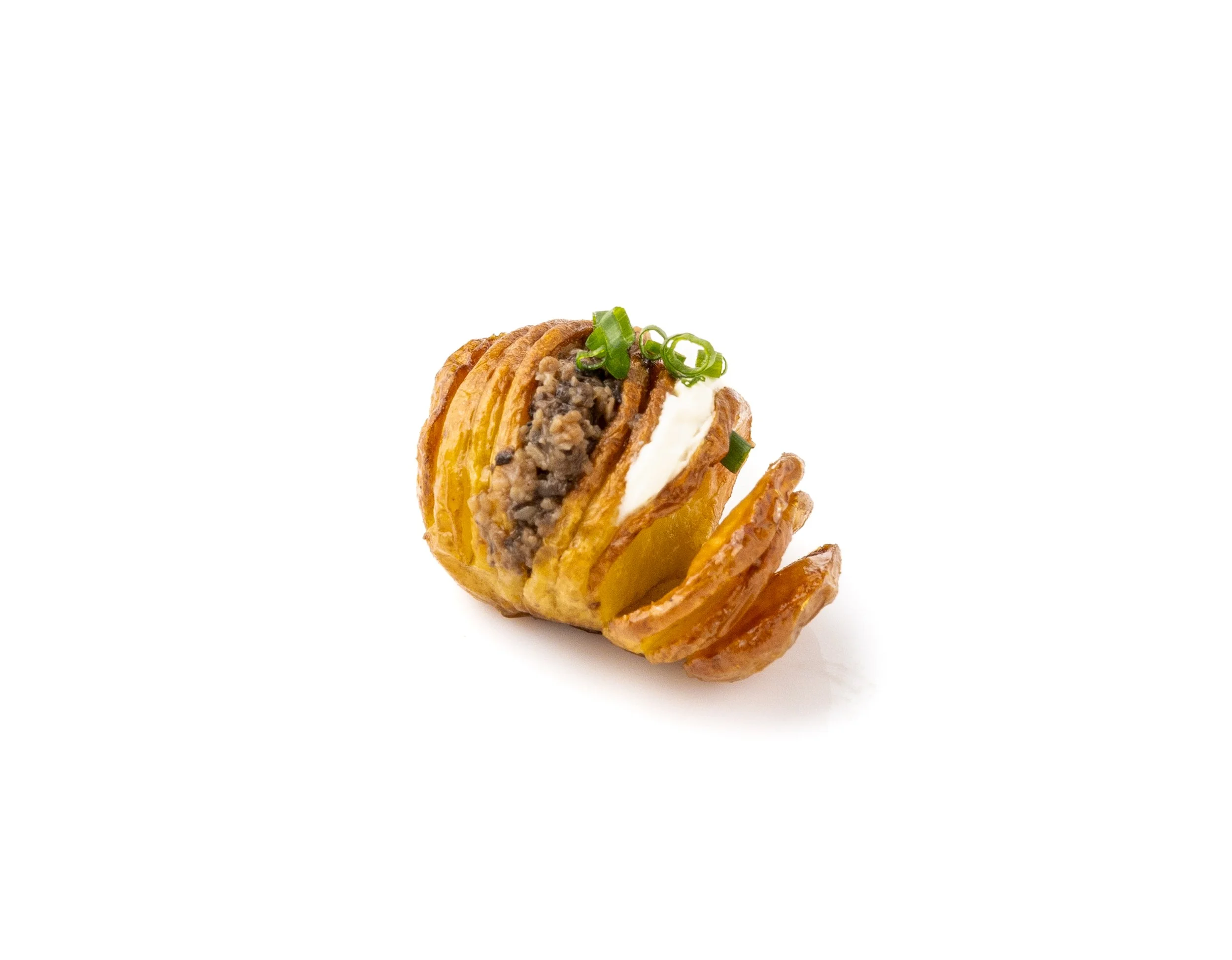 Mini crispy potato basket filled with ground beef, cream, and green onions, garnished with additional green onions.
