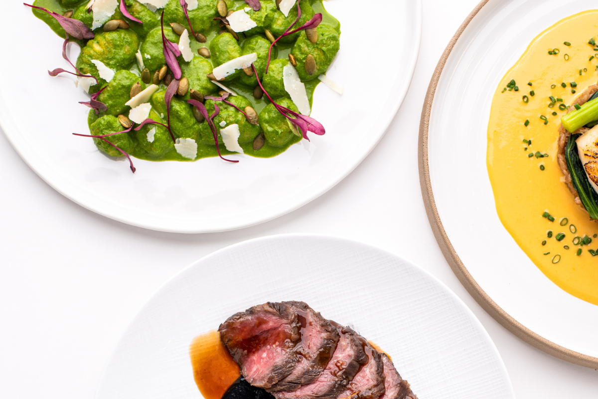 A bunch of plates sitting on a white surface with food on them