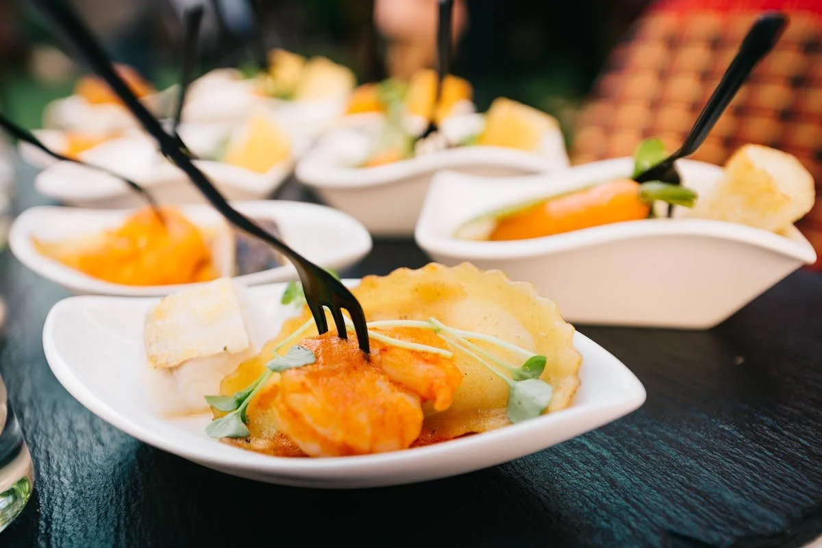 A bunch of plates of food with forks sticking out of them