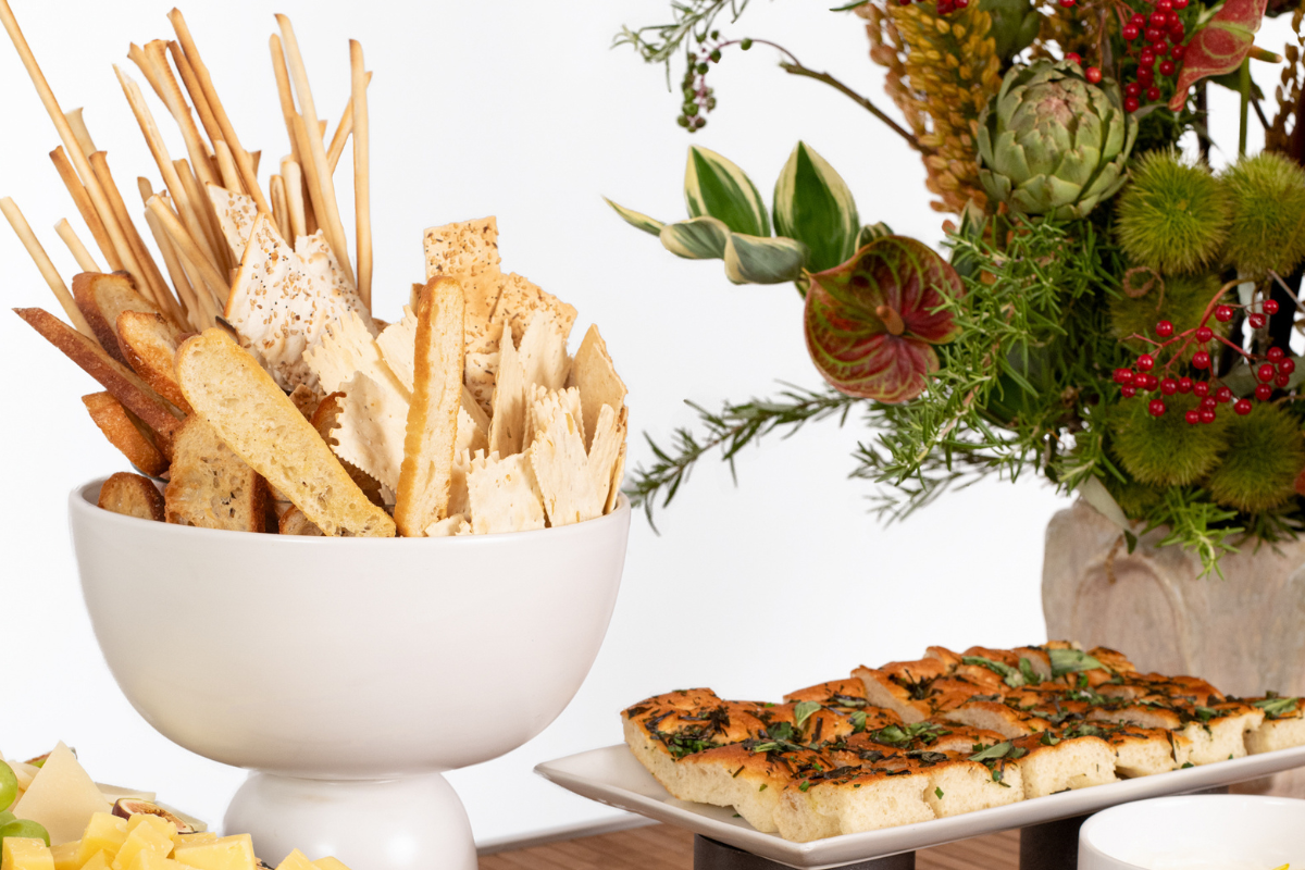 A bunch of different bread types sitting in a bowl and on a platter