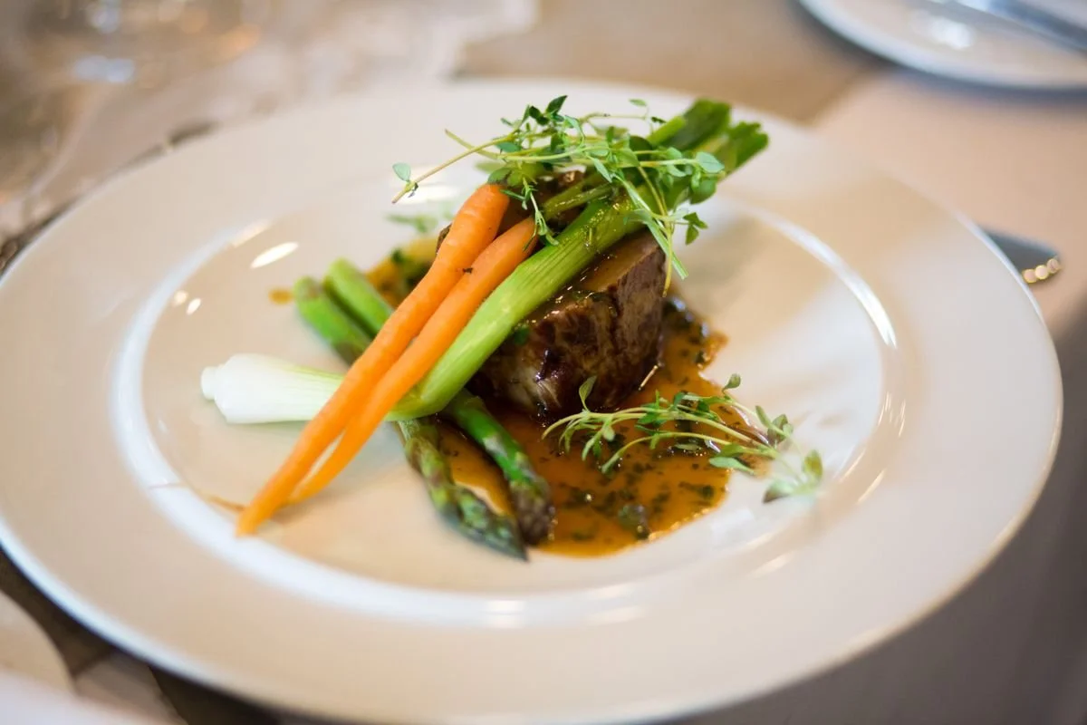 A plate with some meat and vegetables on it