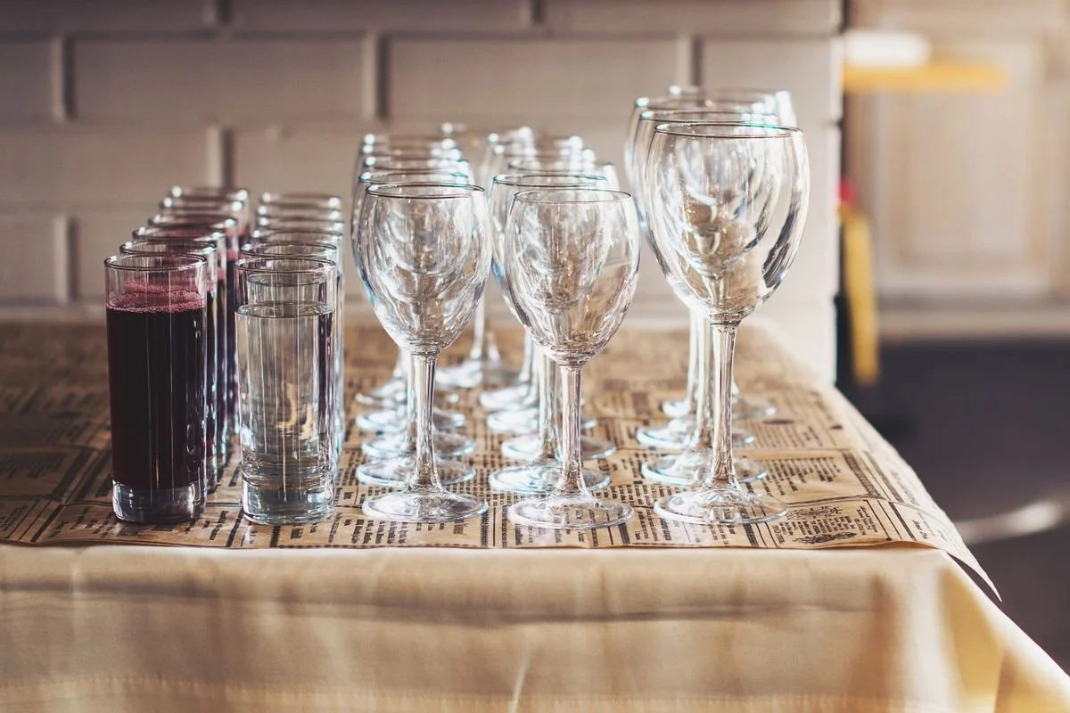 A bunch of glasses with some of them filled with juice