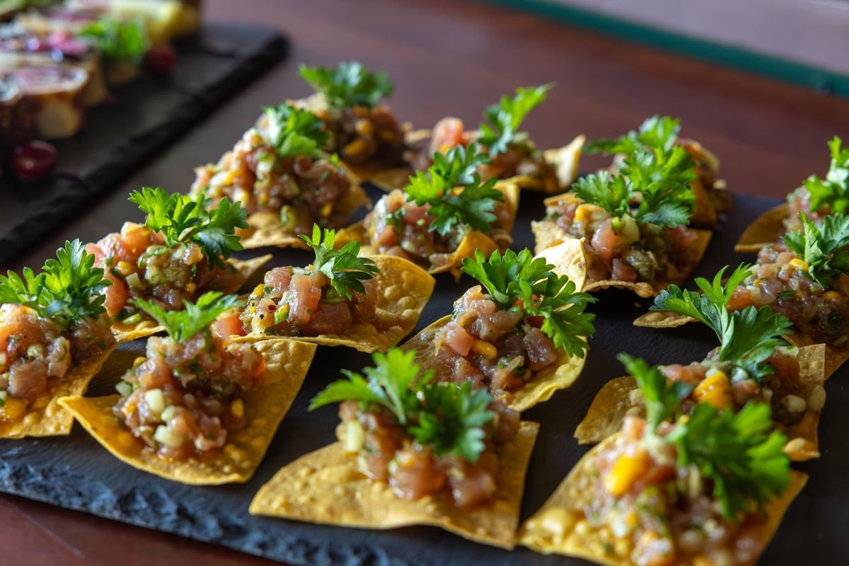 A bunch of chips with some salsa on top of them