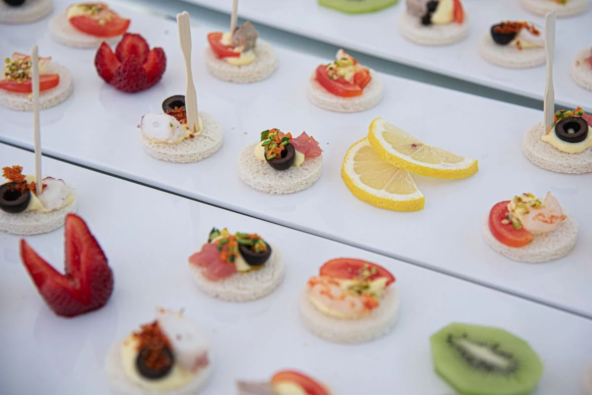 A bunch of cakes and fruit all laid out on a table