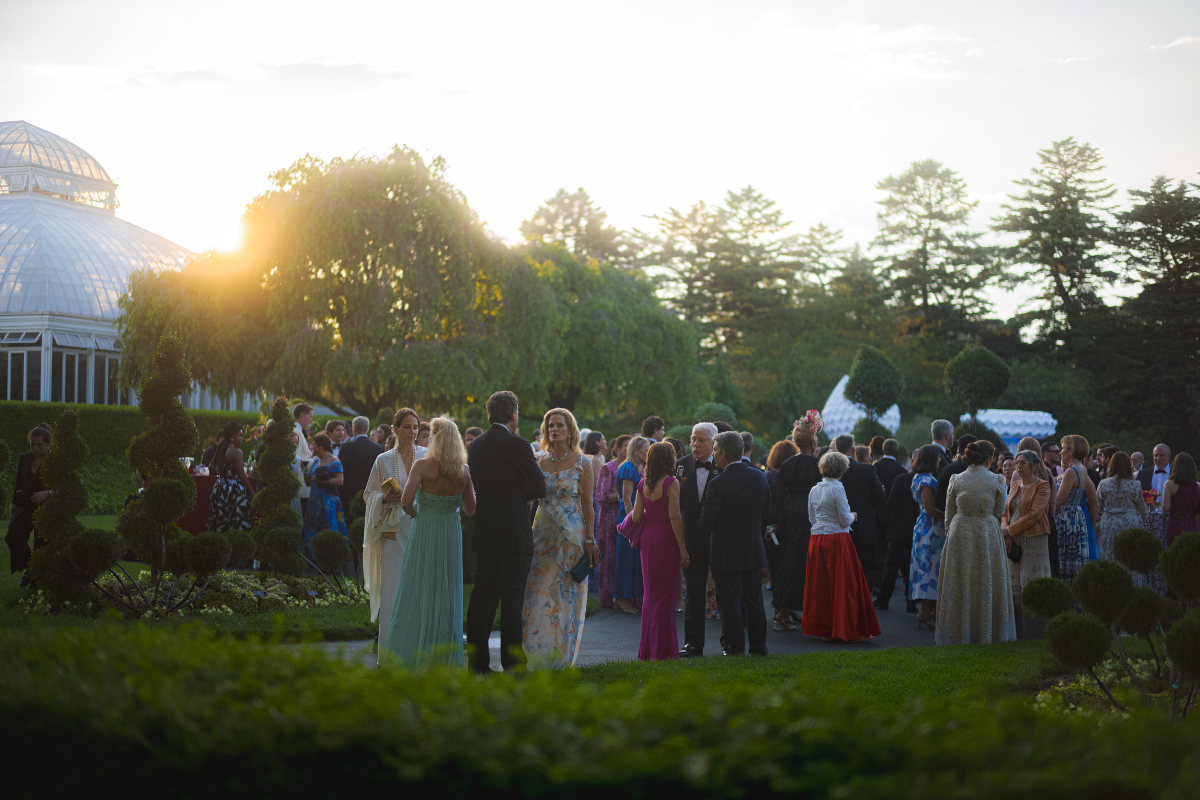 A group of people all outside for a catering party event at a venue