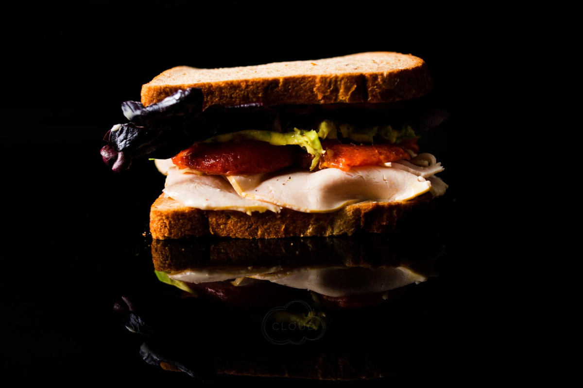 A black background with a sandwich sitting on it