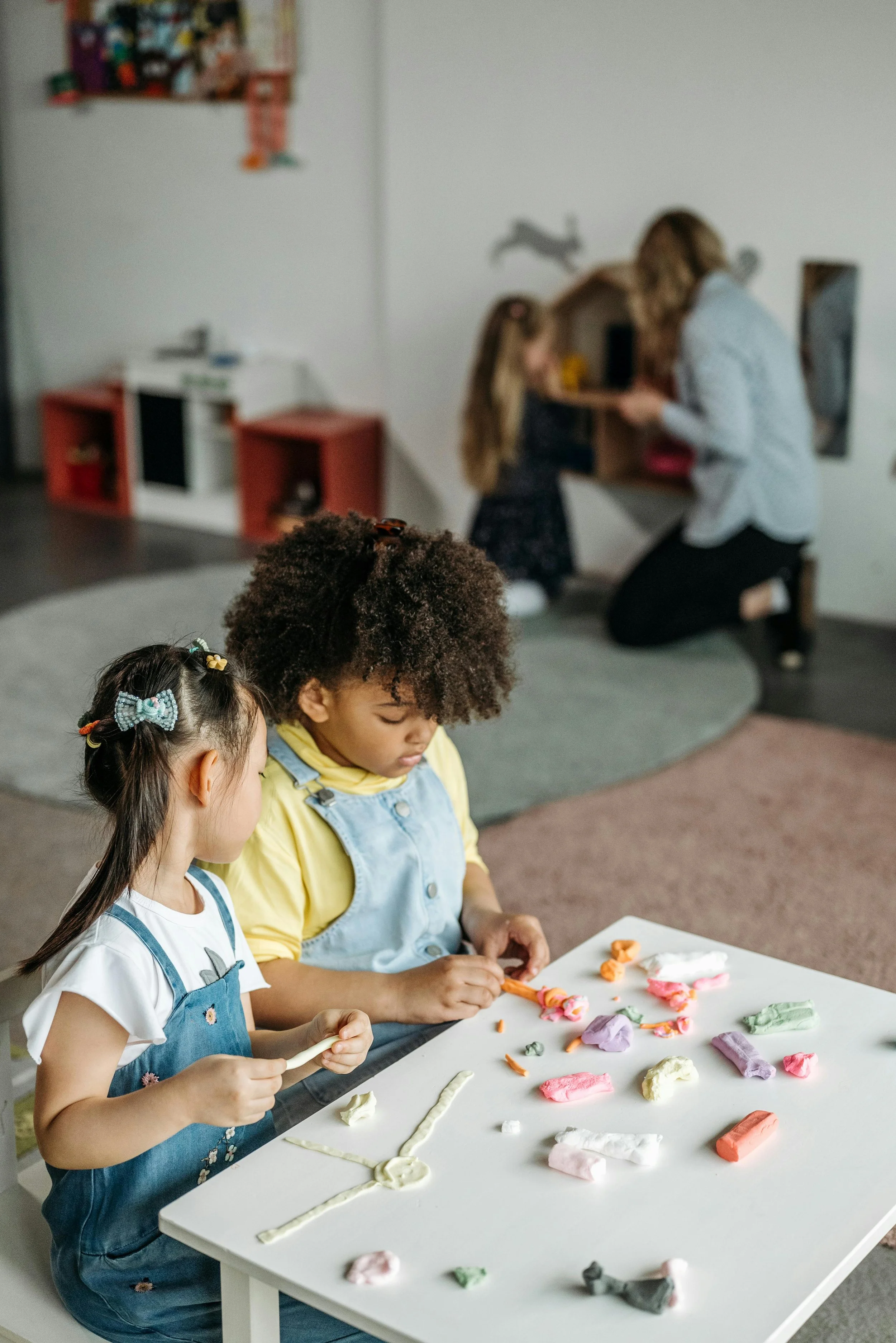 two preschool children playing with clay at a table in a manhattan daycare