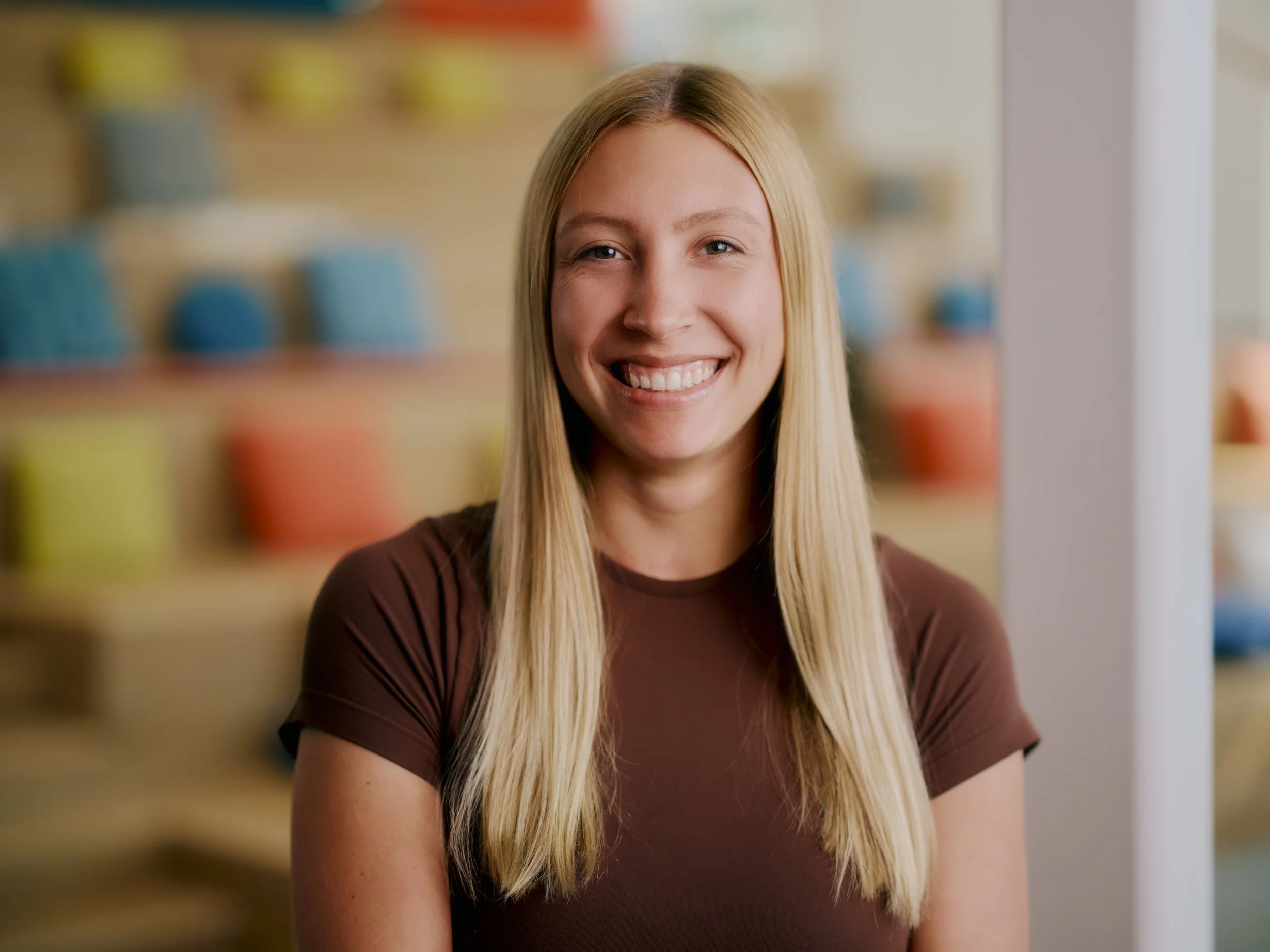 A professional headshot of Kyra Arendt standing in an advertising agency.