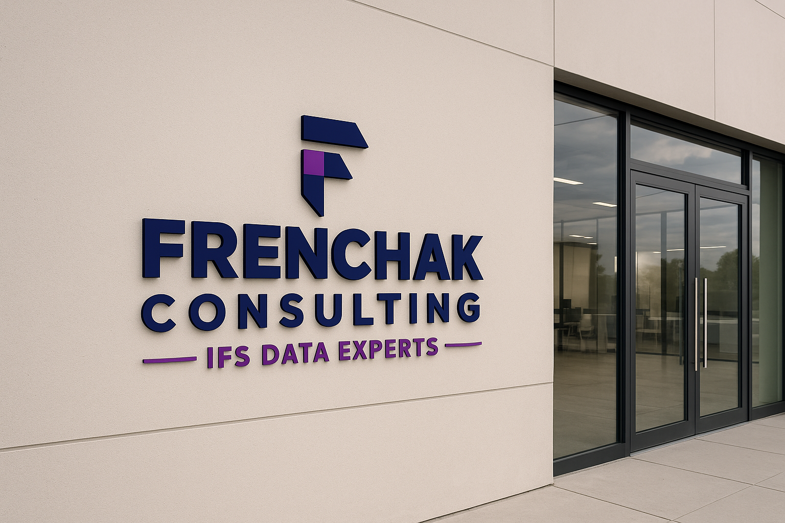 Exterior view of a modern office building with a sign reading 'FRENCHAK CONSULTING IFS DATA EXPERTS' on a beige wall near glass doors.