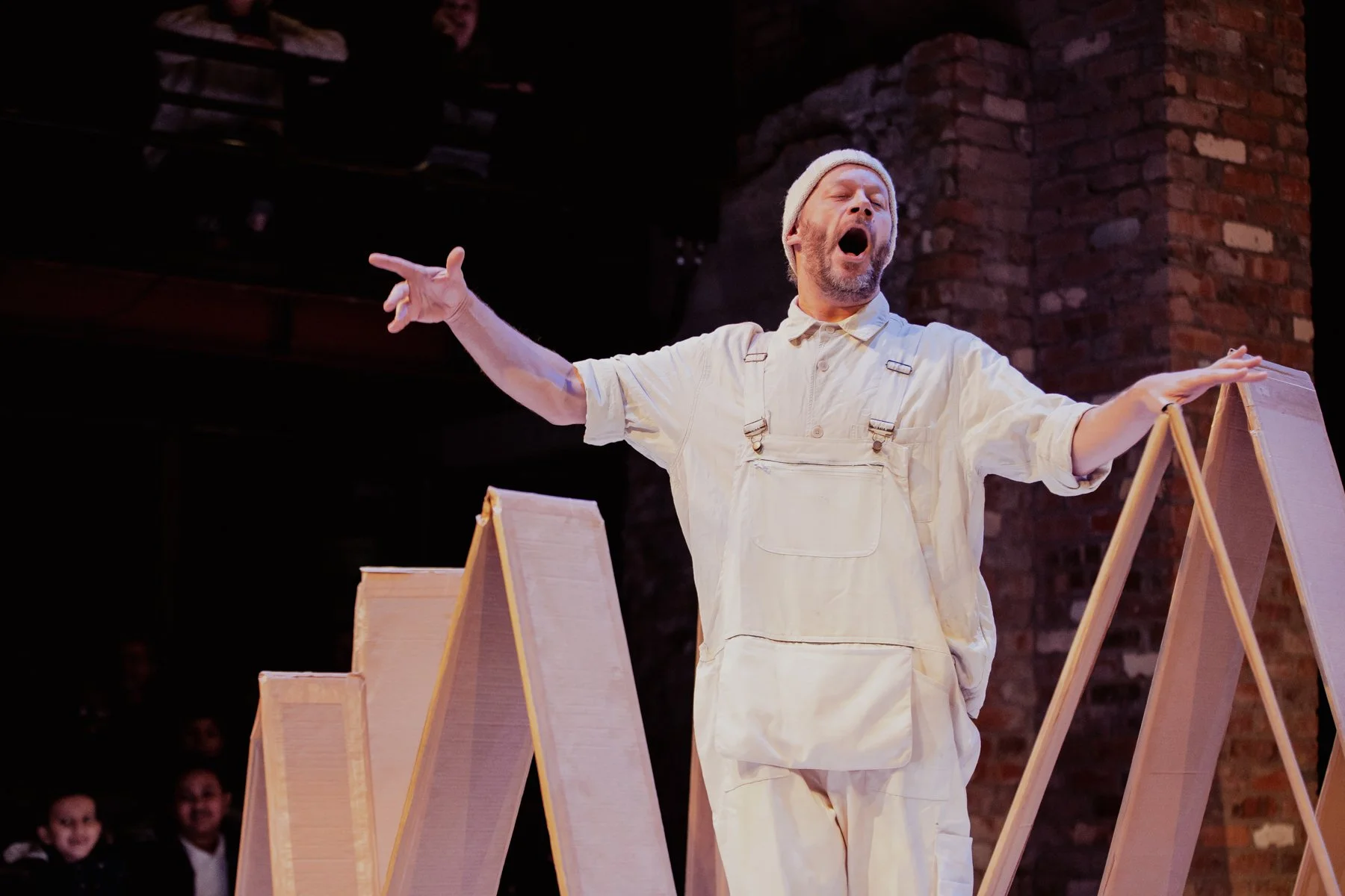 A photo from Belle and Sebastien - performed at Bristol Old Vic. Felix Hayes playing Belle  stands with arms outstretched and mouth open.