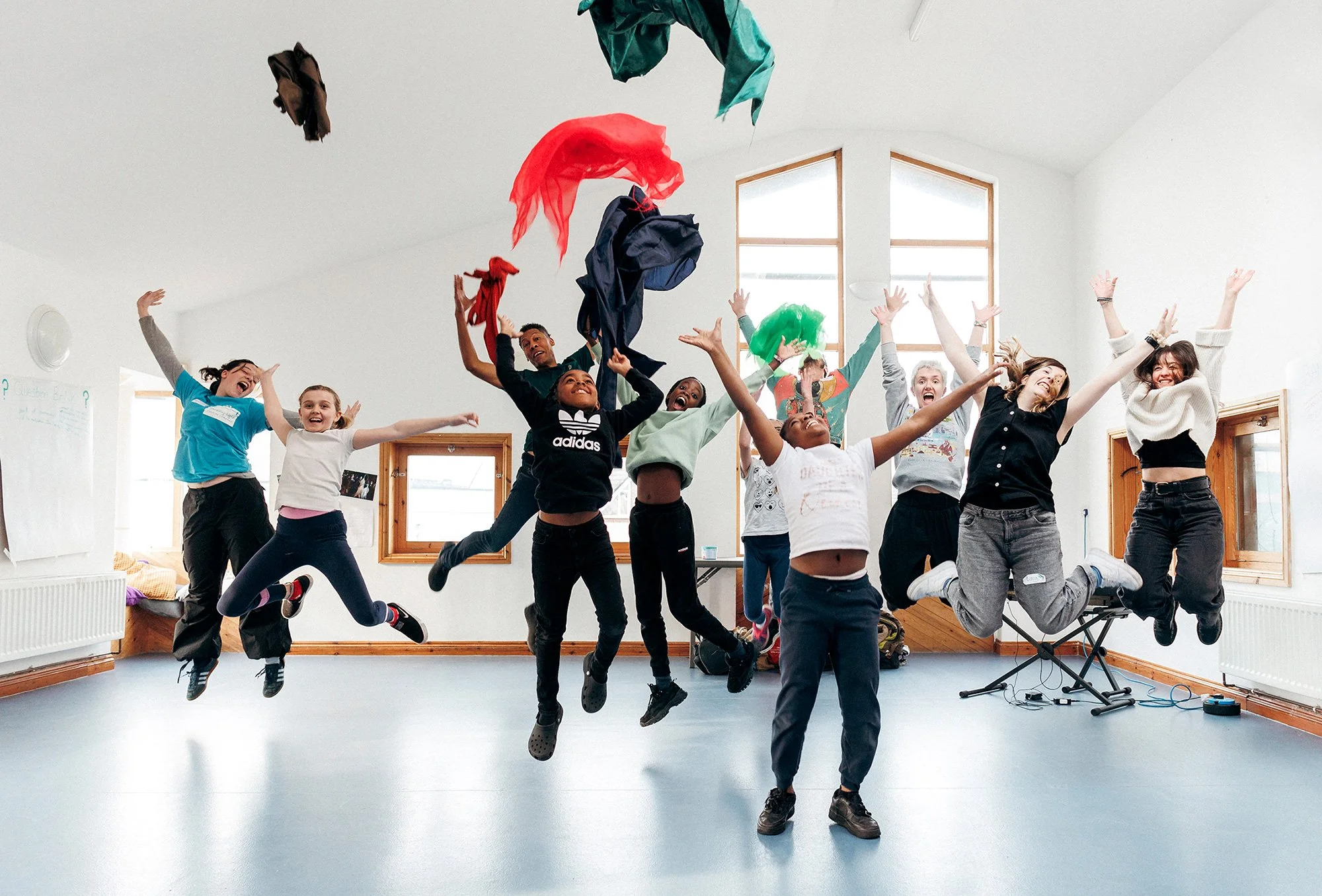 Photo of children and artists jumping in a gleeful manner