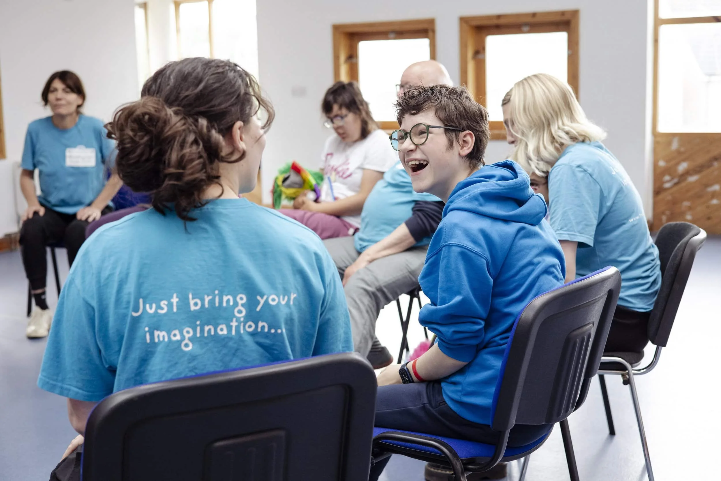 Photo of a young person smiling and laughing with a Travelling Light facilitator.