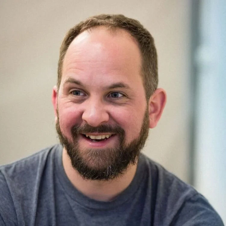 A headshot of Adam Peck