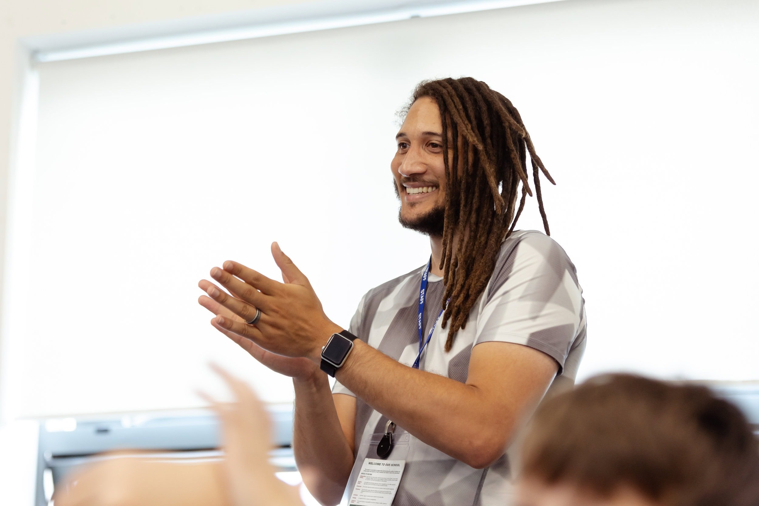 Young adult smiling and clapping at a workshop