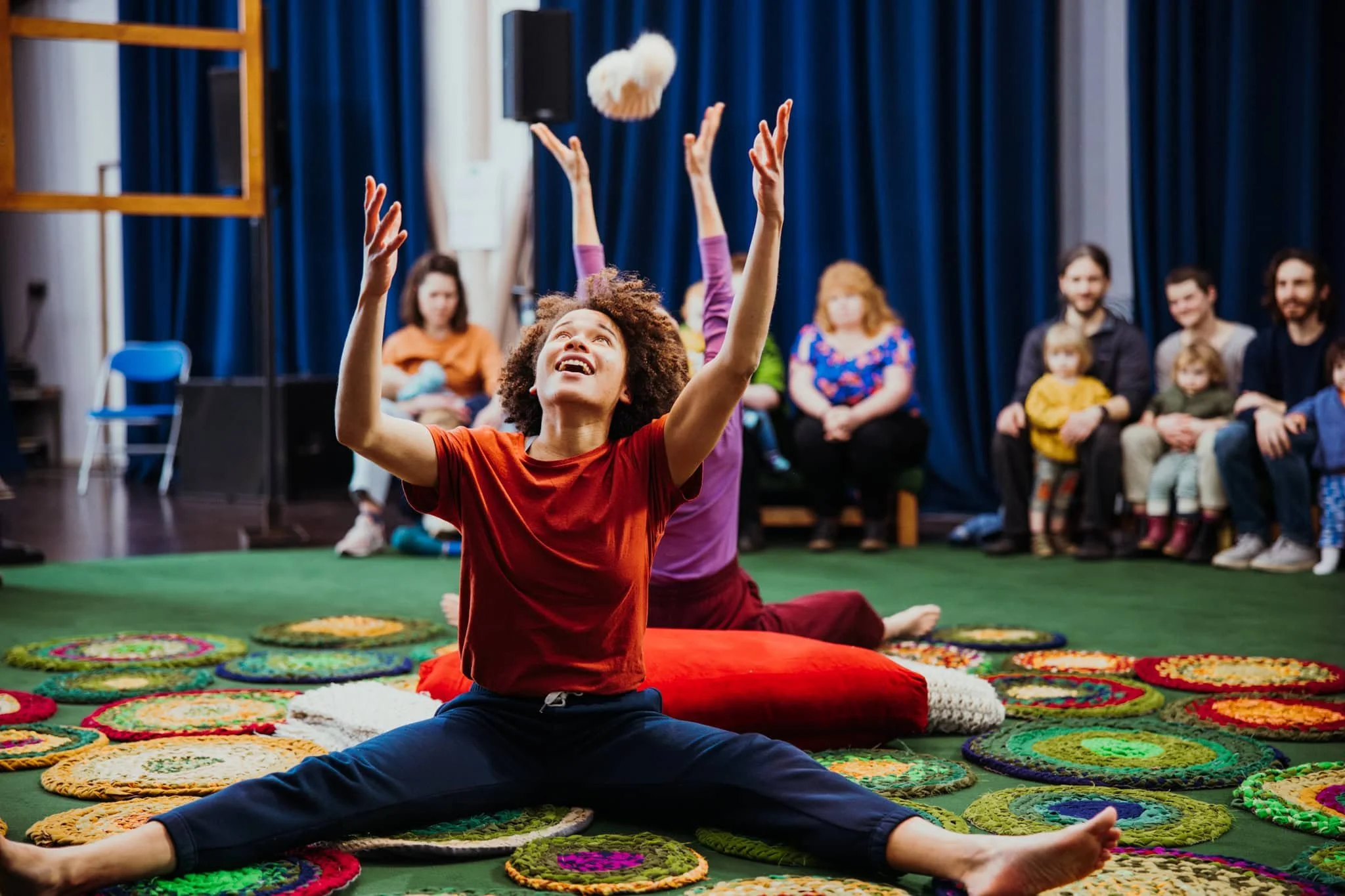 Smiling young people throwing a ball at a family performance