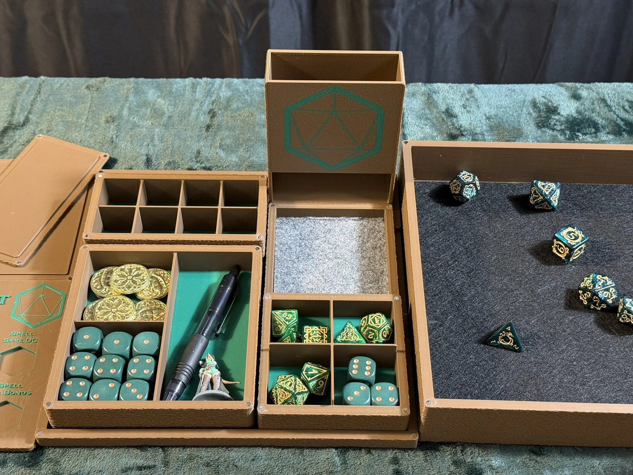 Tabletop role-playing game accessories including dice, miniatures, and storage boxes on a green cloth surface.