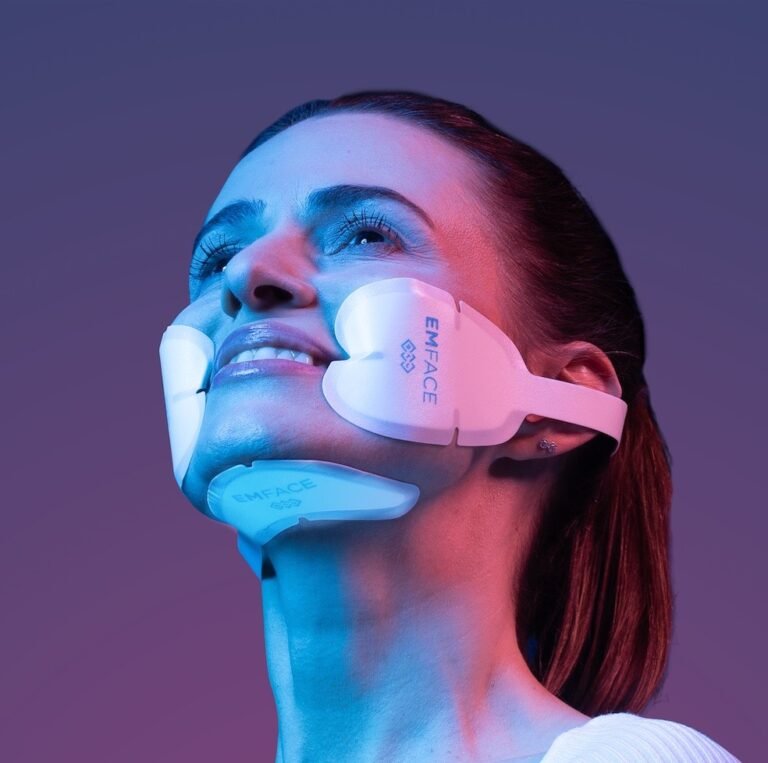 Image of Emface Product on the face of a model in pink and purple lighting.
