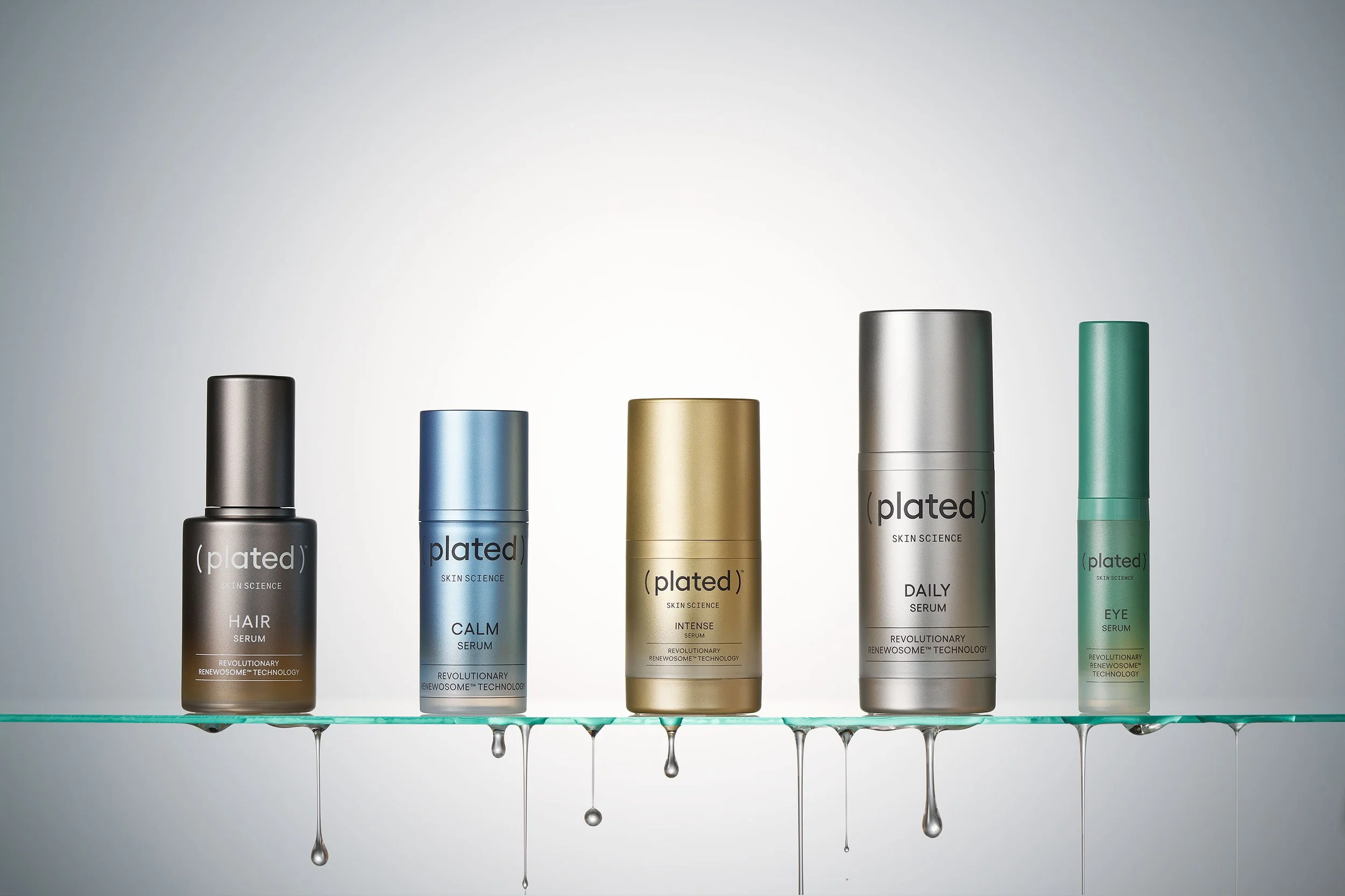 Image of Plated Skin Science products lined up on a glass shelf.