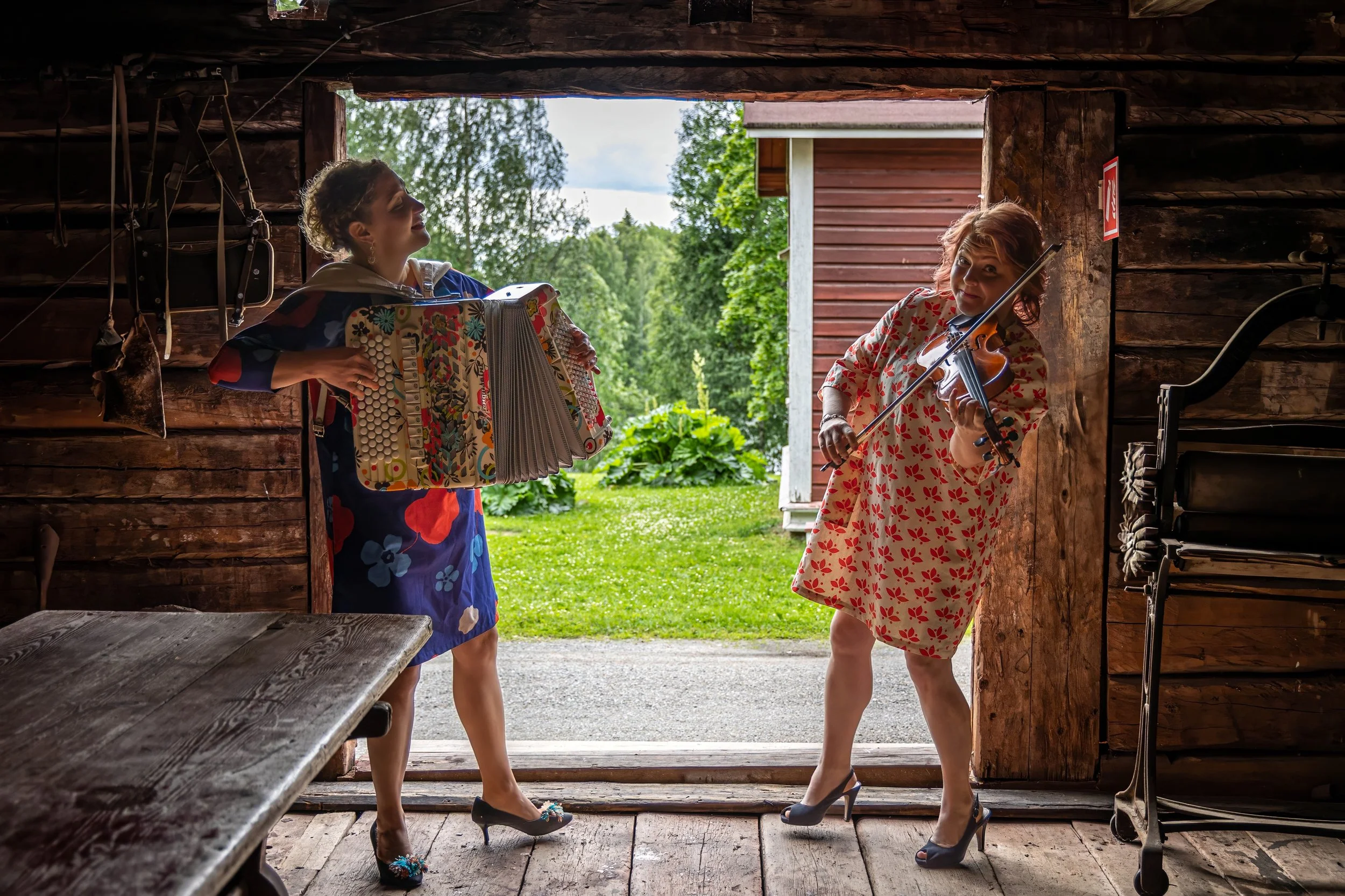 Viulisti ja harmonikkataitelija esiintymässä energisesti lavalla. 