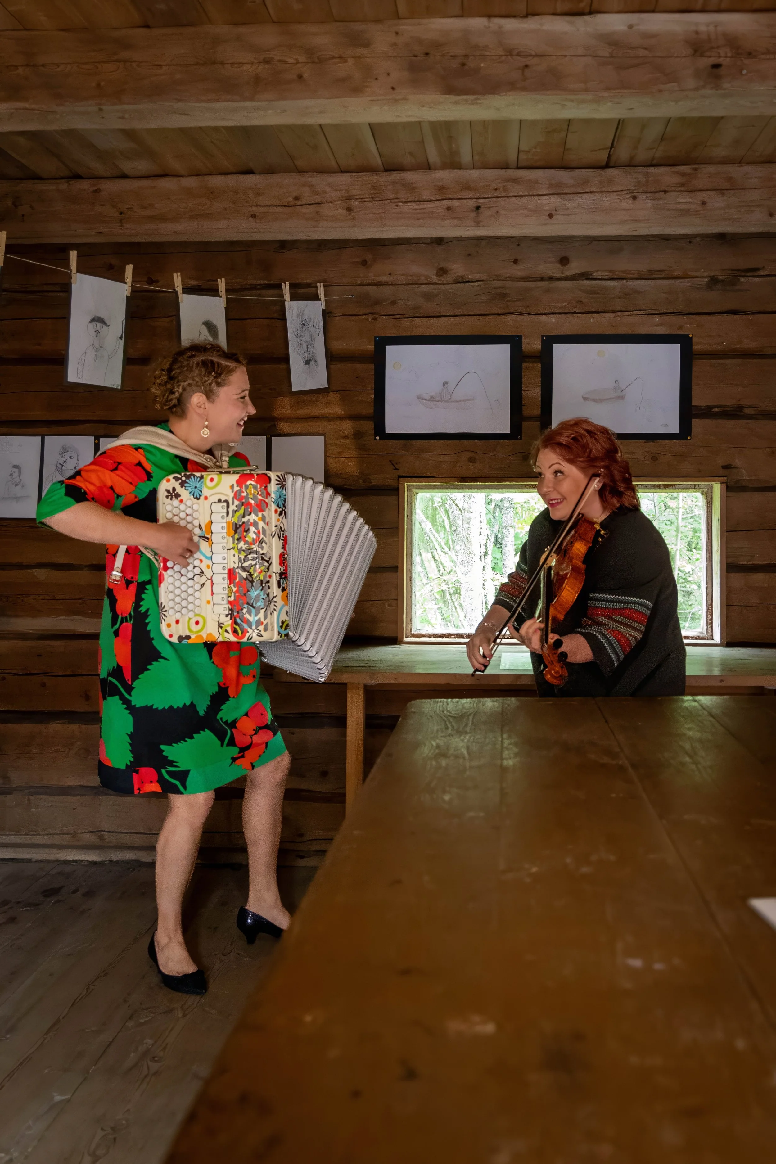 Riitta soittaa viulua ja Petra harmonikkaa kotiseutumuseon historiallisessa ympäristössä. Viulun ja harmonikan yhteissoitto luo lämpimän ja perinteitä kunnioittavan tunnelman.