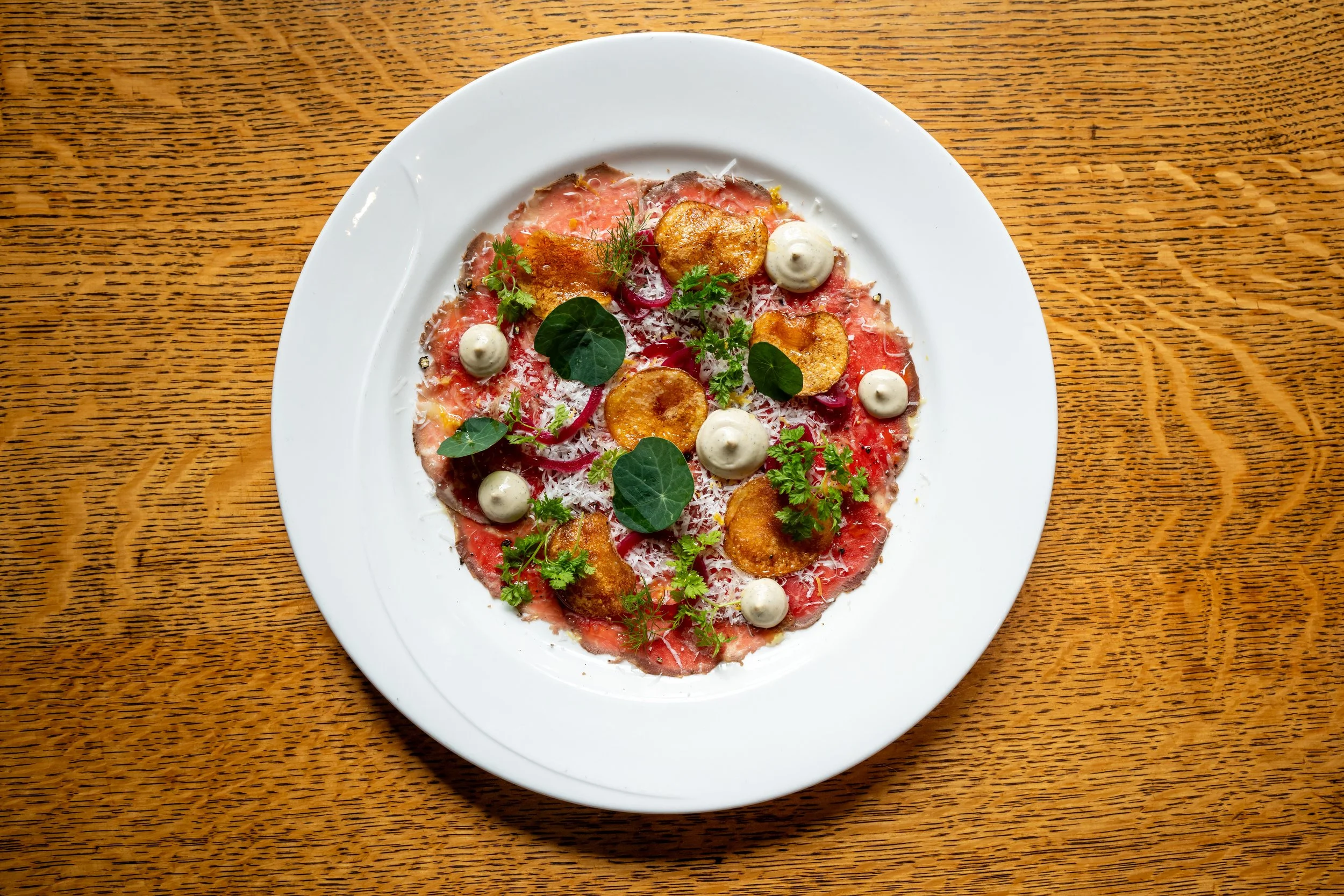 Beef Carpaccio delicately styled and placed as a Small Plate.