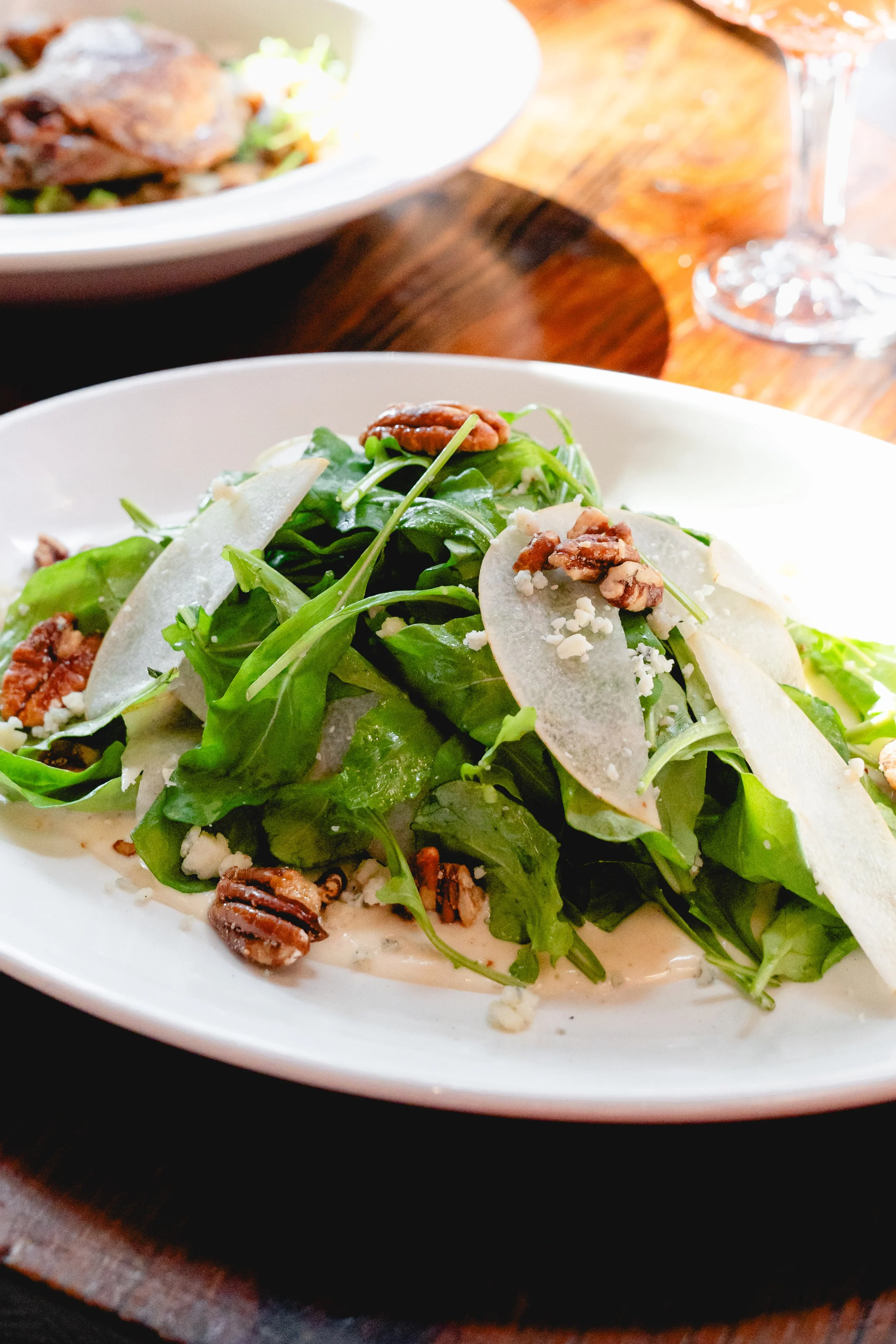 A seasonal salad featuring Spinach & Pears with walnuts and blue cheese topped with a vinaigrette.